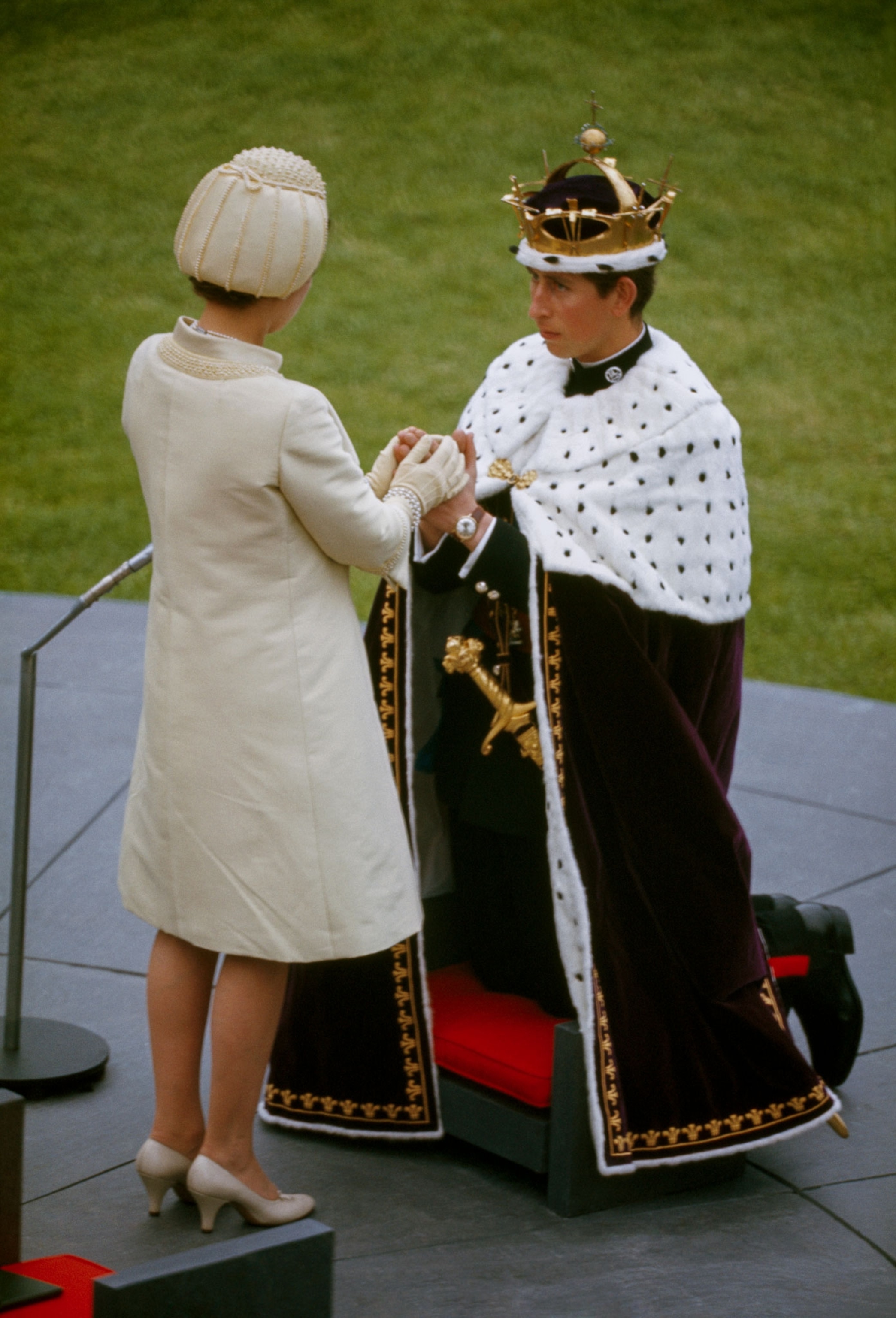 Prince Chales kneels before Queen Elizabeth II during his investiture ceremony