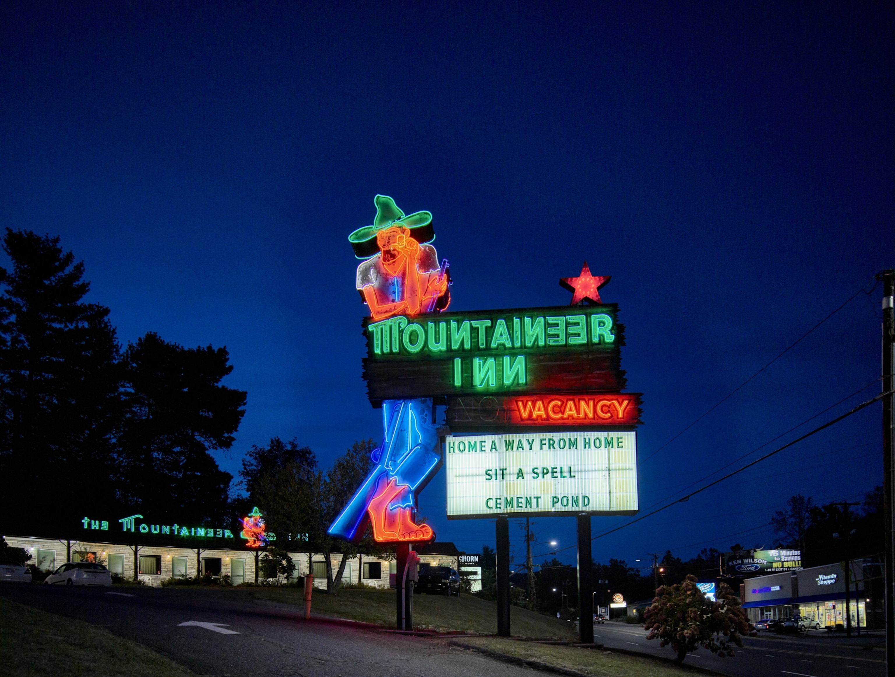 Neon cowboy sign notifying visitors of hotel vacancies for the Mountaineer Inn in Asheville, North Carolina