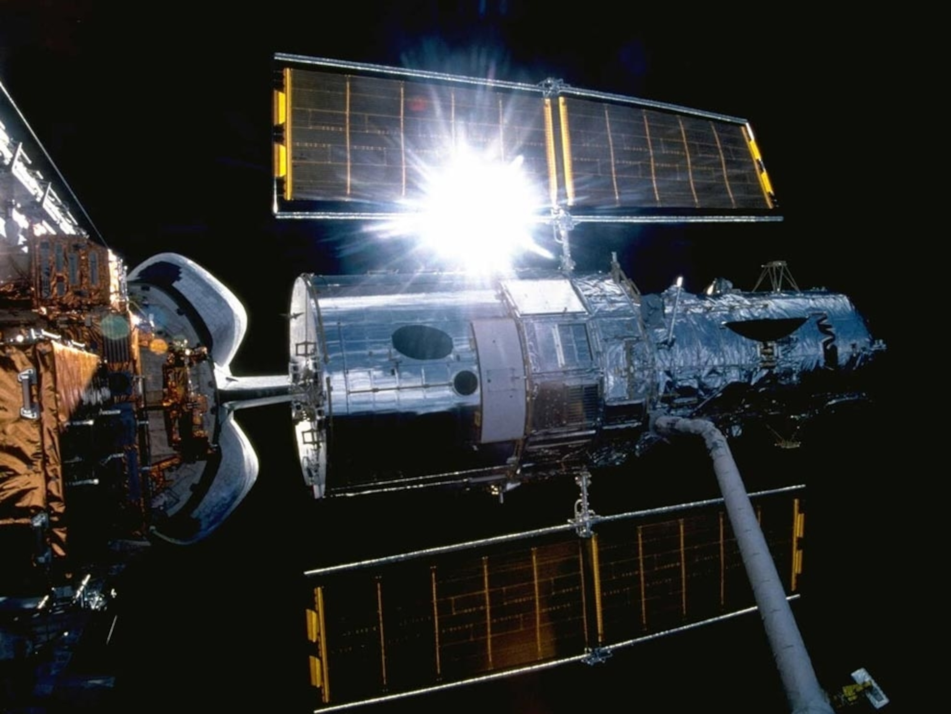 sunlight glinting off Hubble's solar array