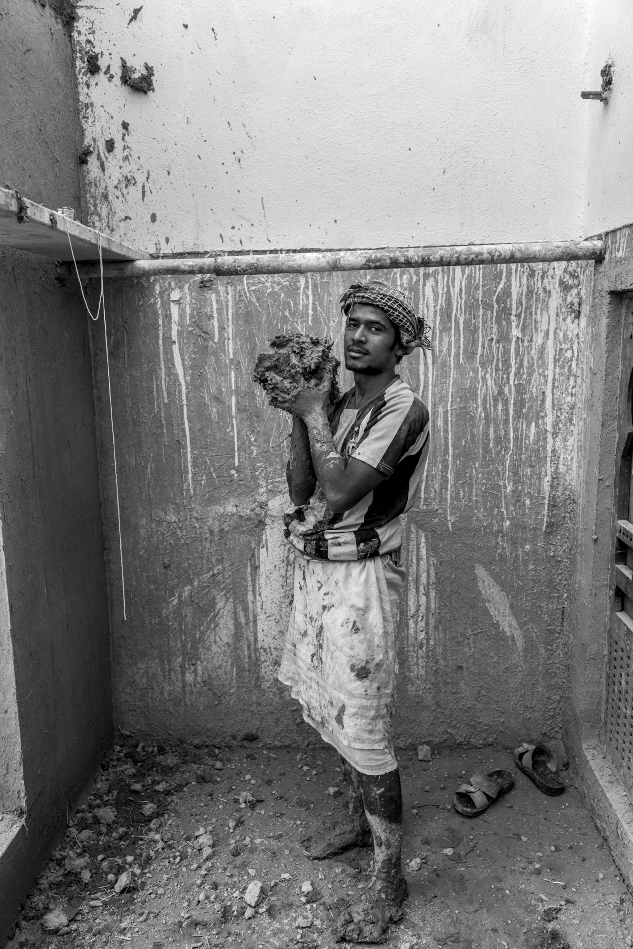 Picture of young man holding a lump of mud.