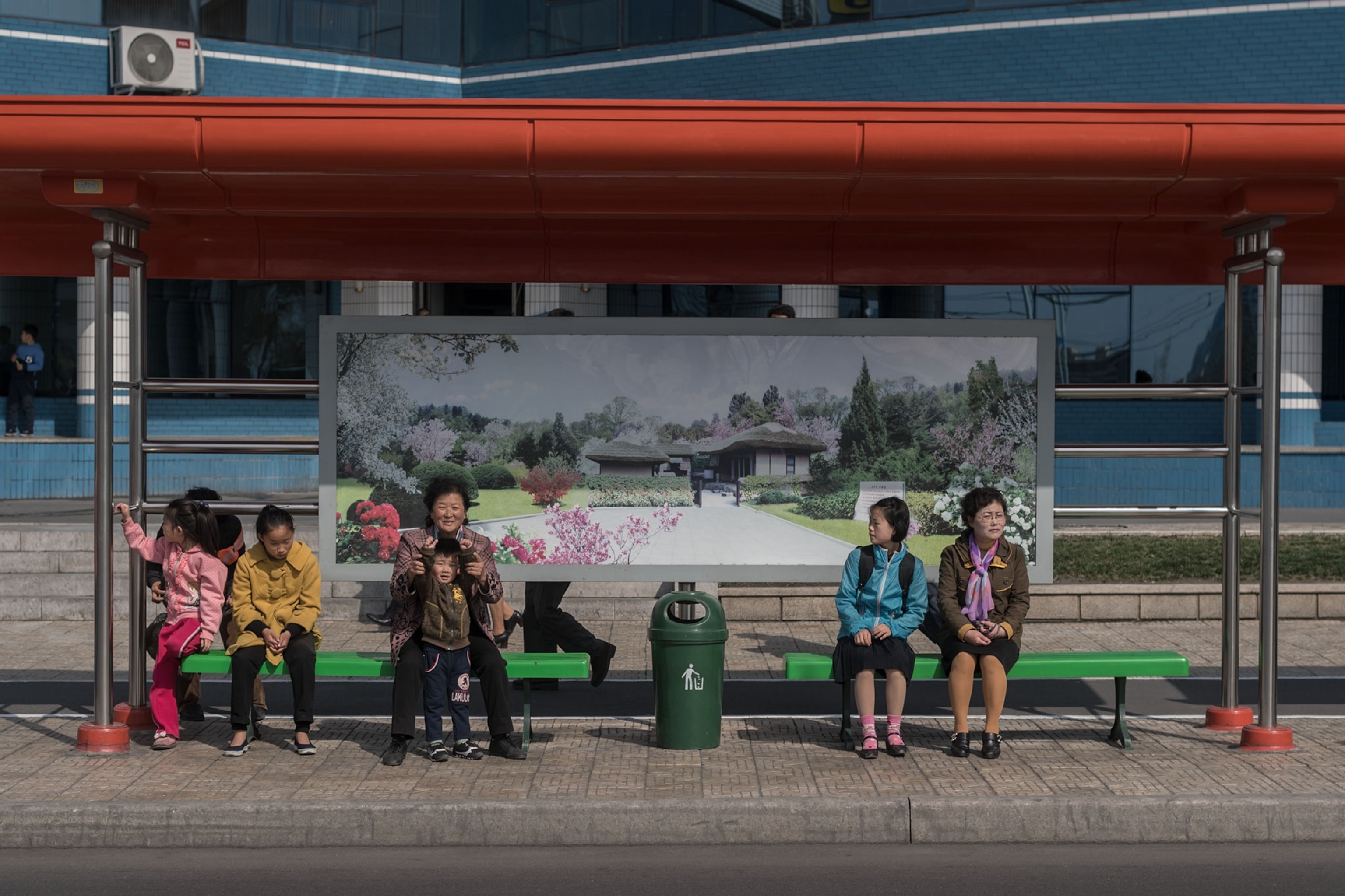 people waiting at a bus stop in North Korea
