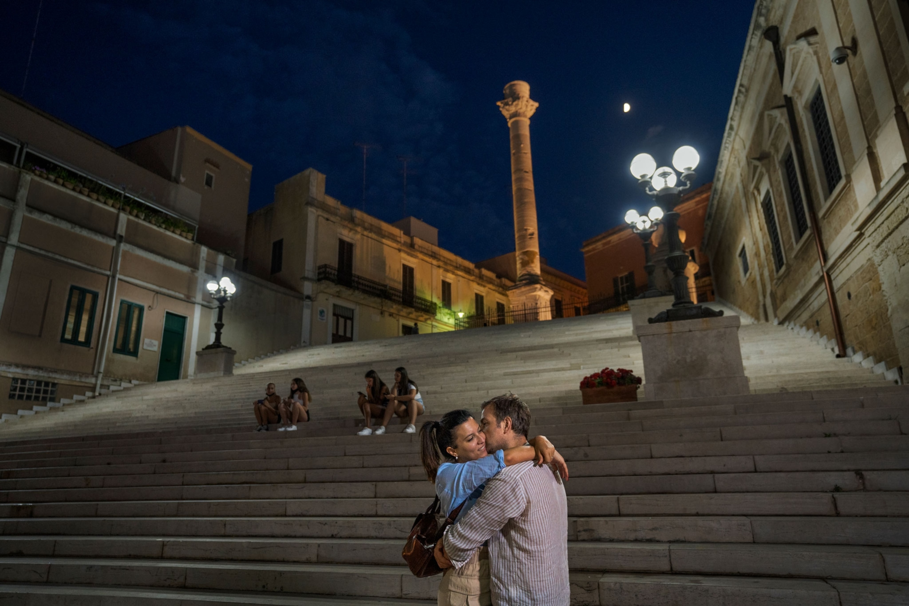 A couple embraces at the Port of Brindisi.