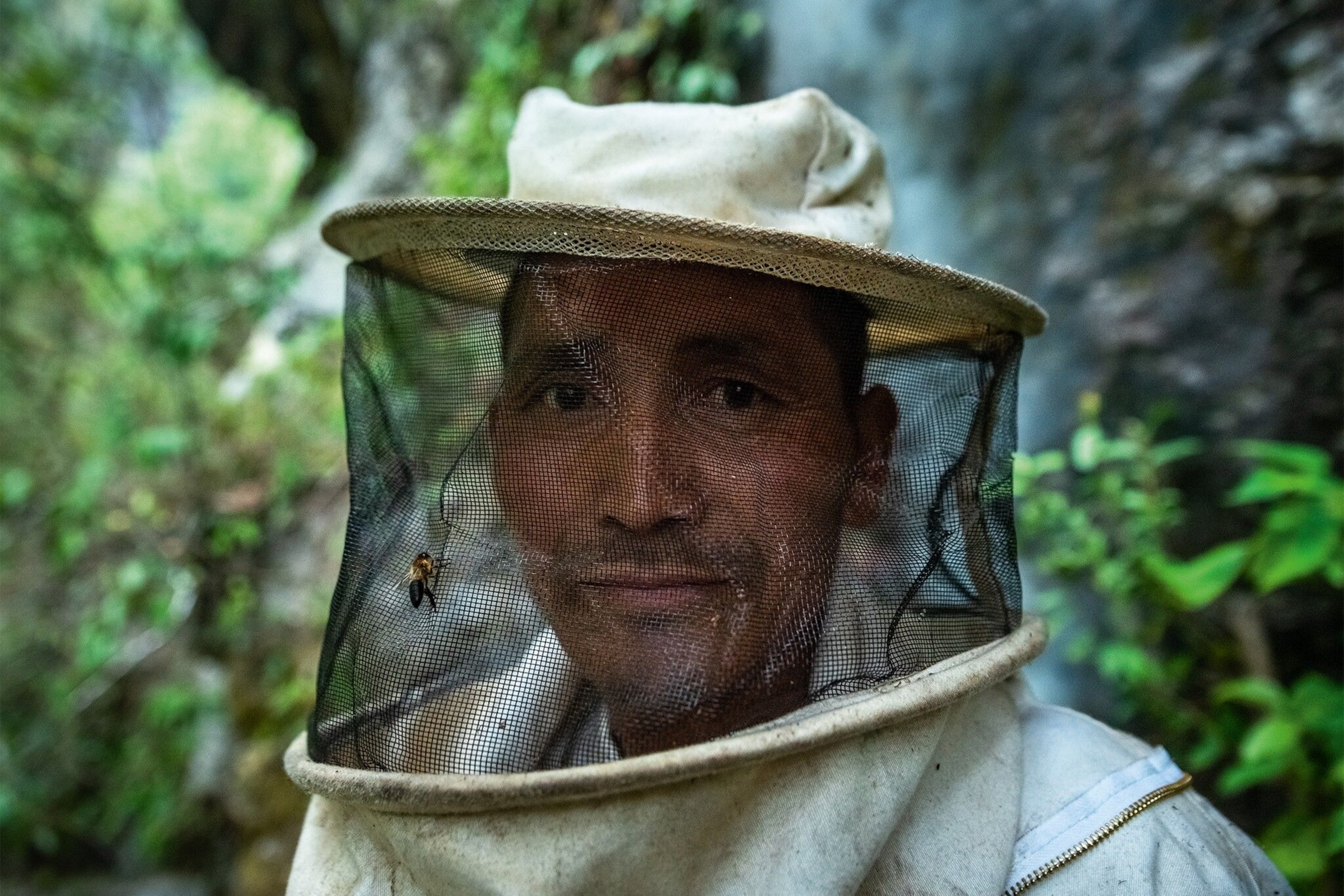 Honey hunter, wearing a net over his face to protect him against the bees’ stings