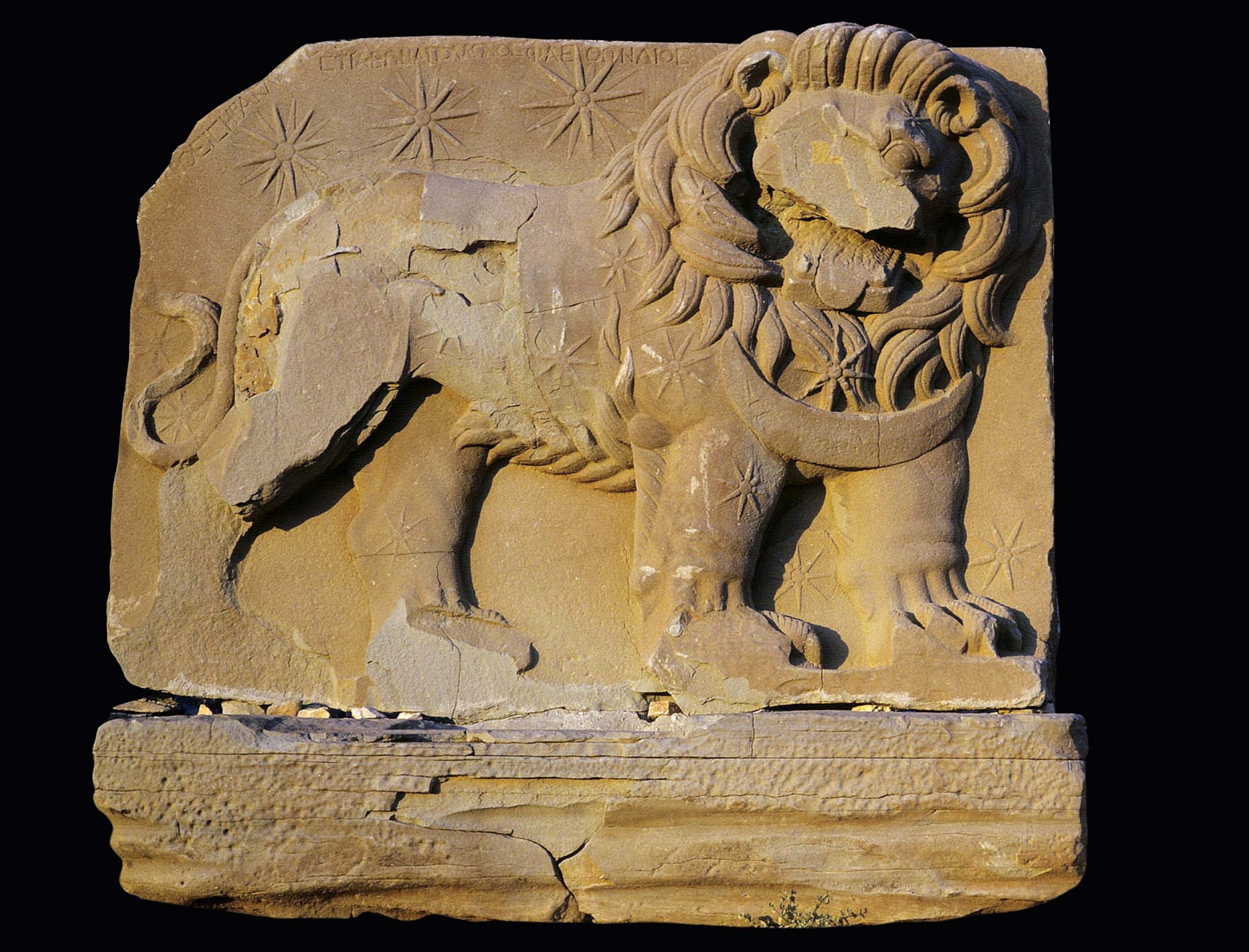 A stone relief of a lion with stars behind it