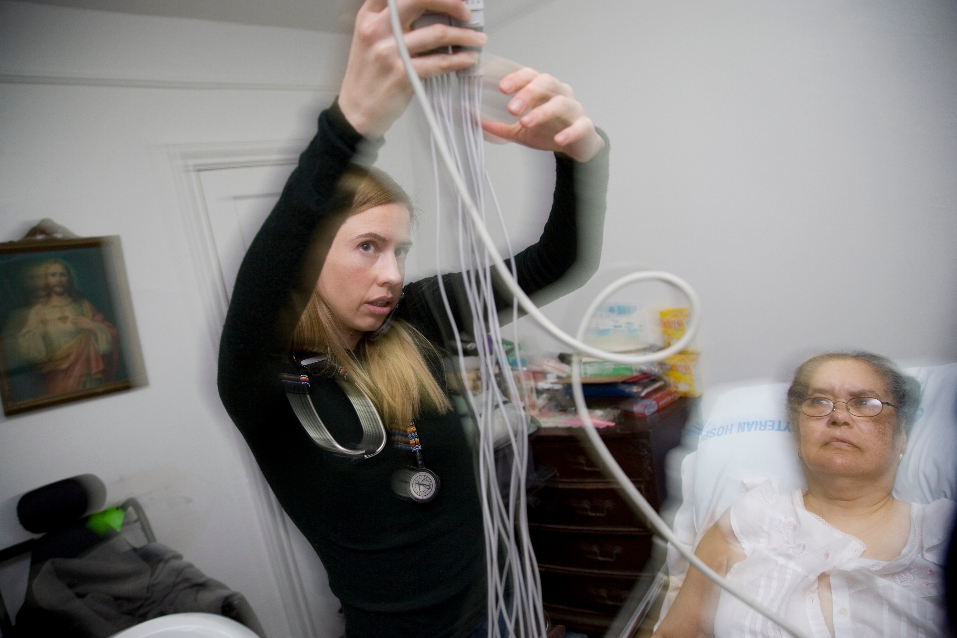 a doctor administers an EKG to a patient at home