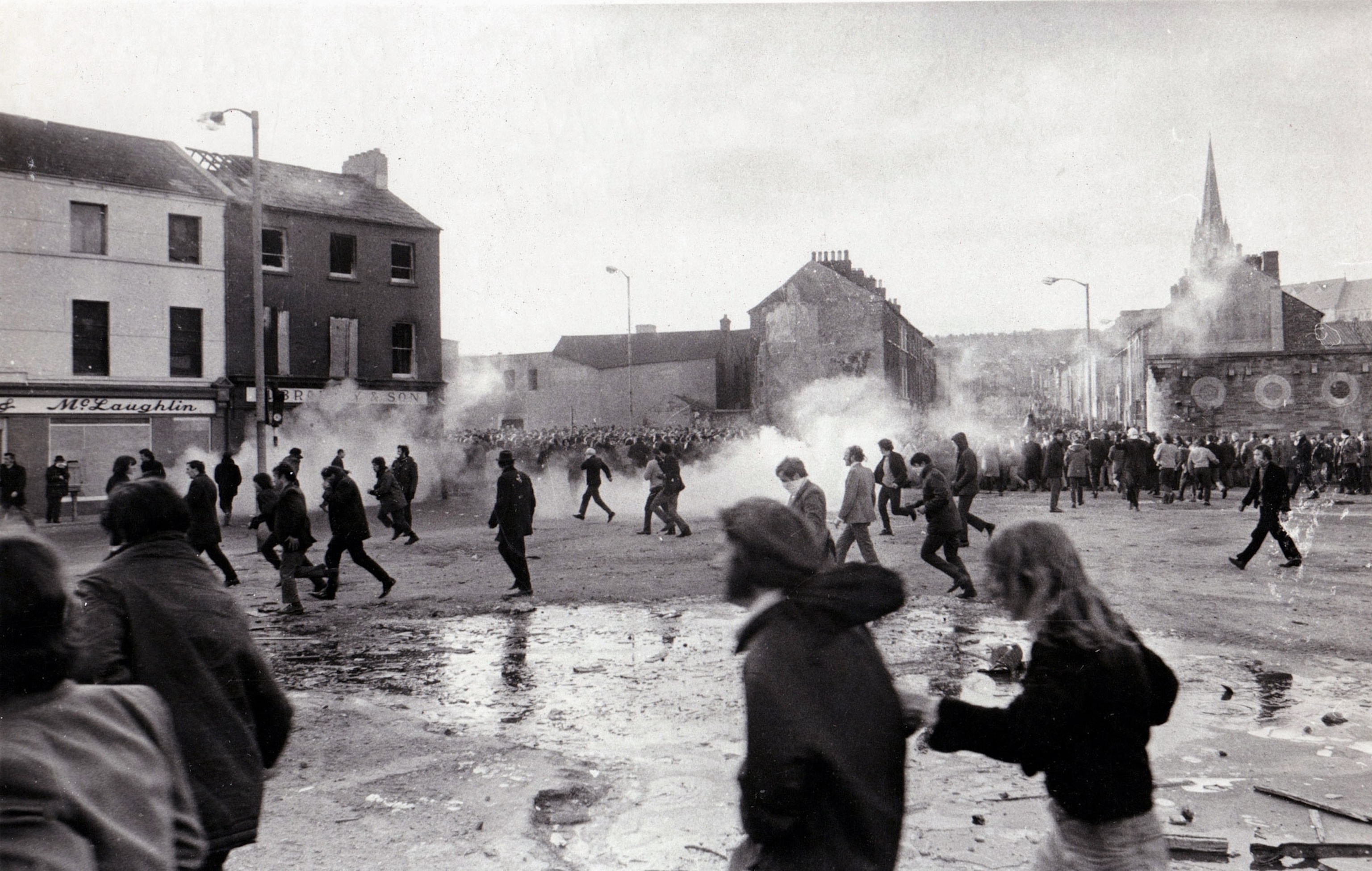 a black and white photo of demonstrators running from tear gas during the Bloody Sunday riots in Ireland in 1972