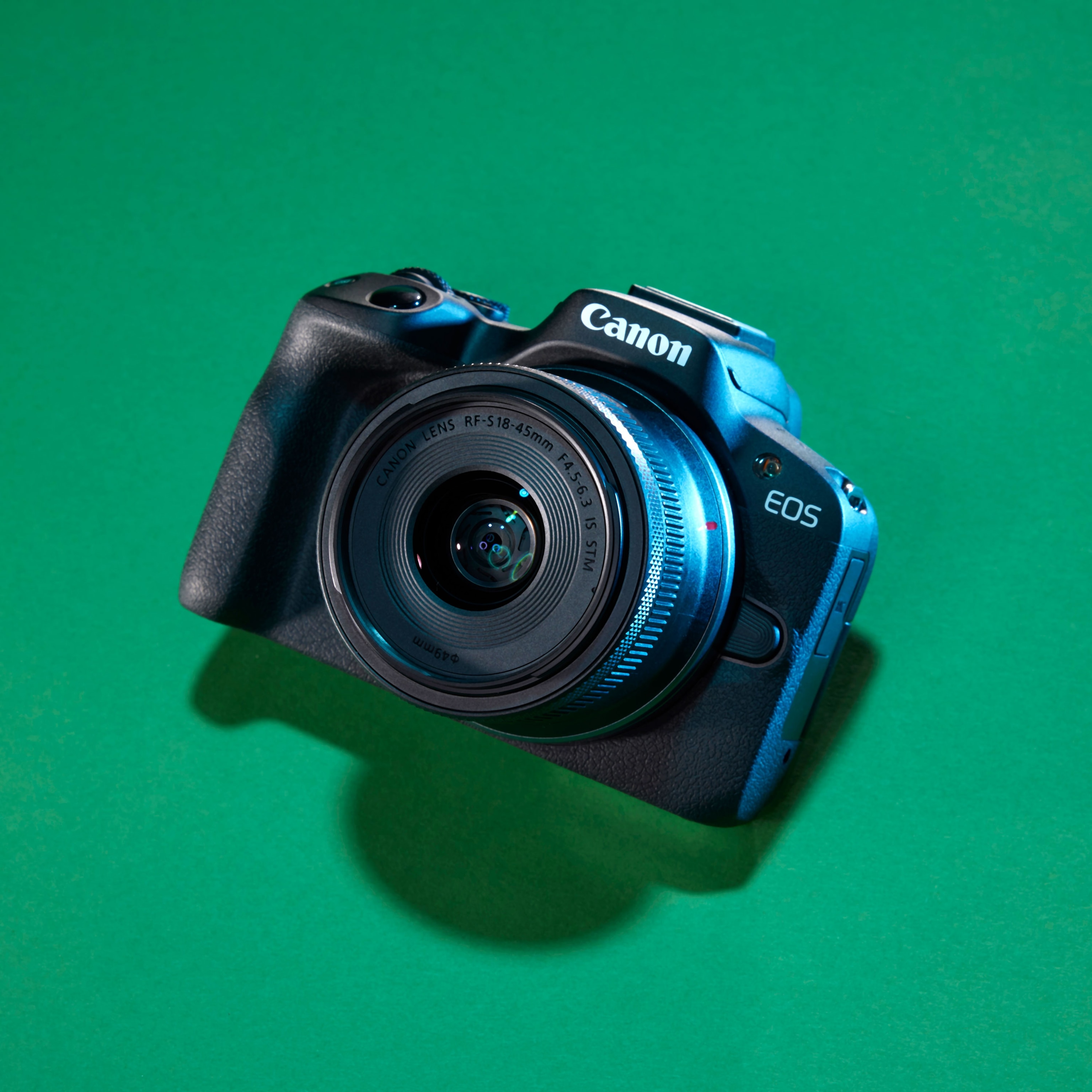 Studio photograph of the Canon R50 camera against a green background
