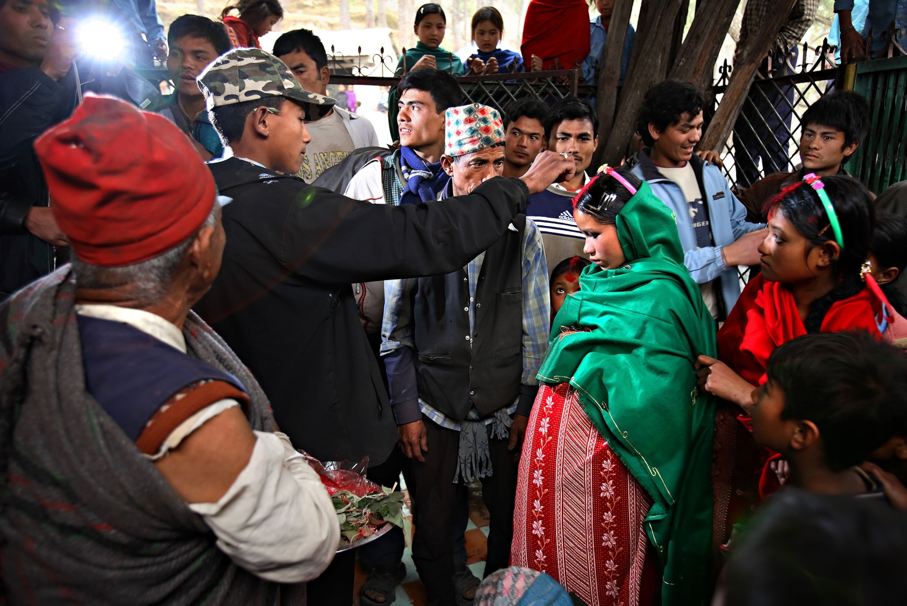 a 17-year-old groom putting vermillion on the forehead of his bride, nine-months pregnant, fourteen-year-old Niruta Bahadur Balami, in Kagati, Nepal