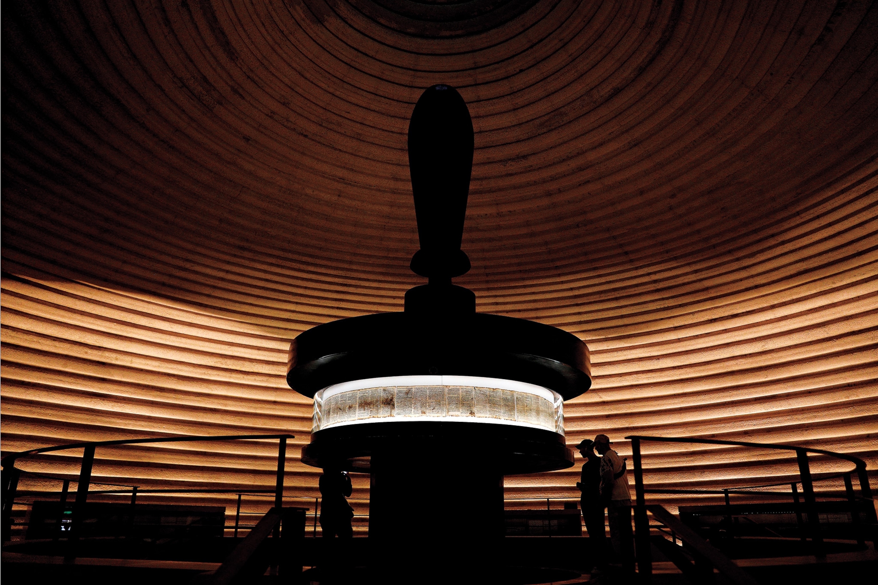 Visitors examine a display of the Dead Sea Scrolls in the Shrine of the Book at the Israel Museum in Jerusalem.