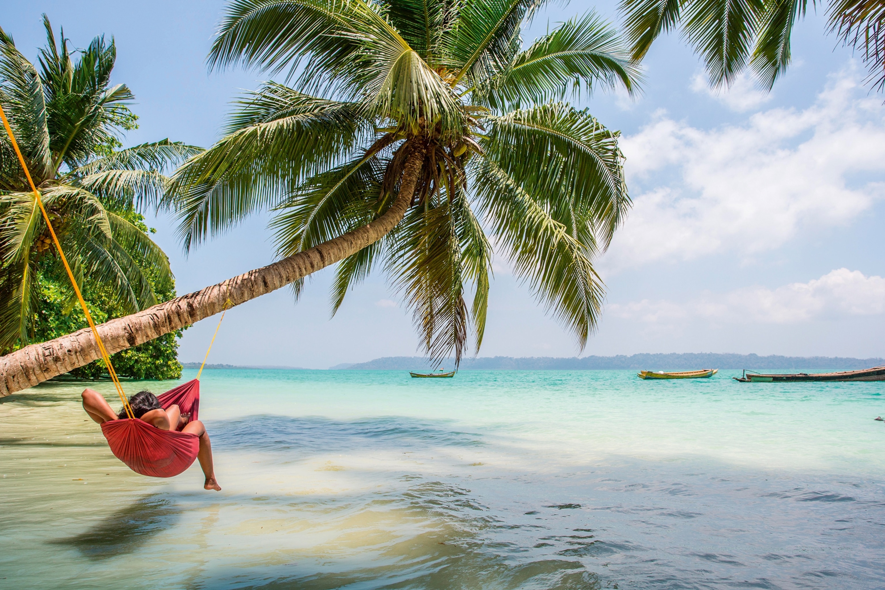a woman on a hammock on the beach