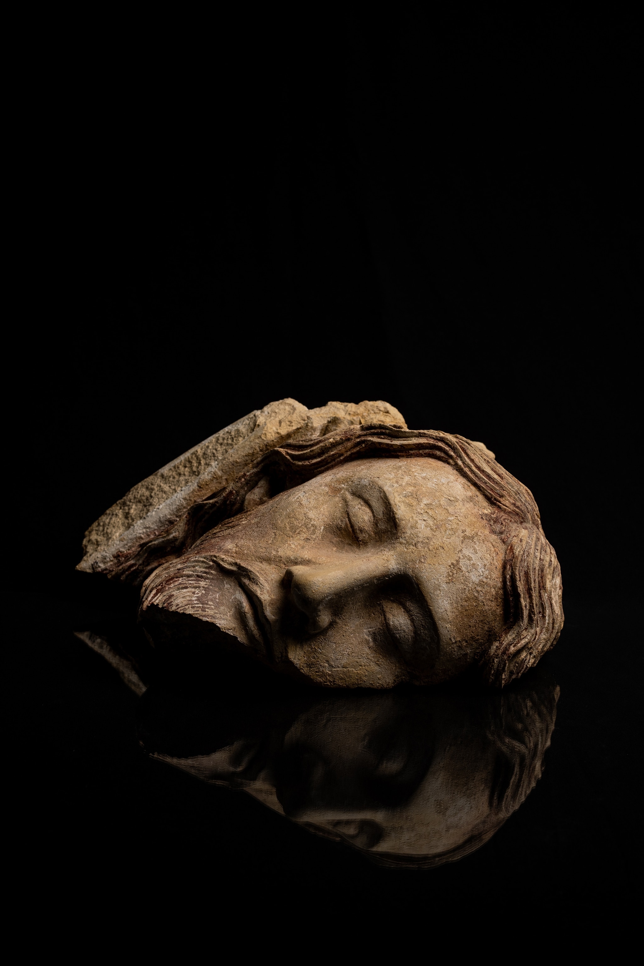 A sculpture of the face of the dead Christ with eyes closed.