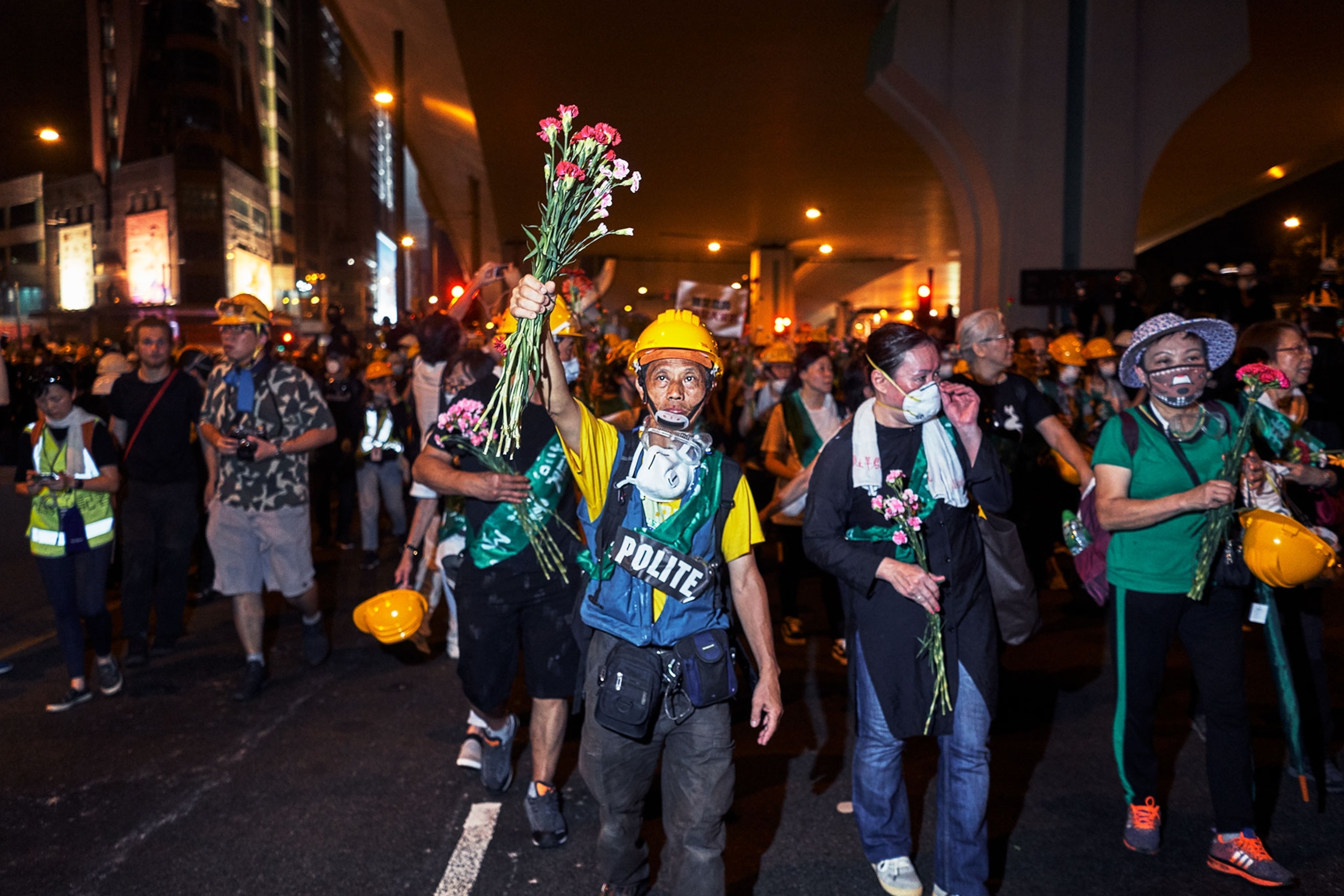 an elderly man protesting with flowers in hand in Hong Kong