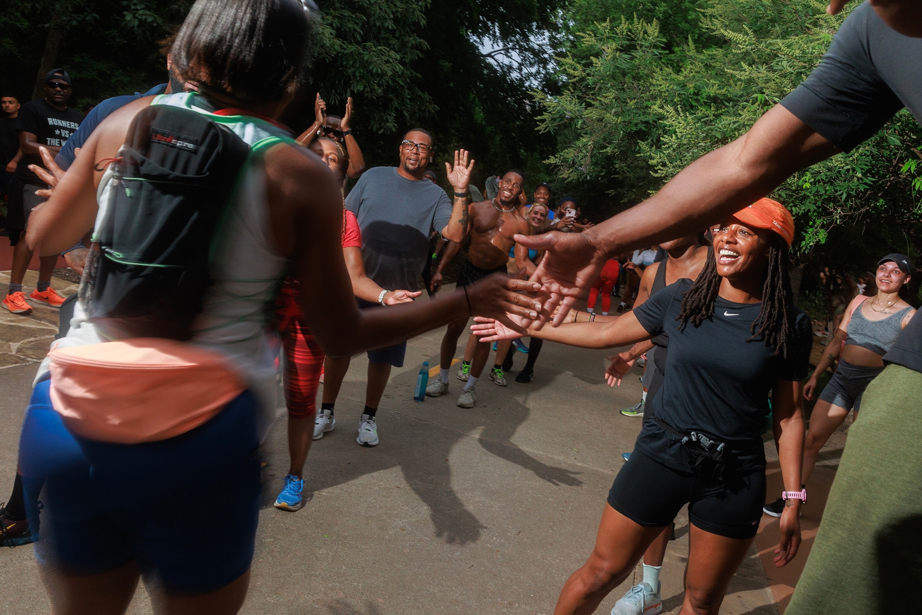 Runners high five teammates after a practice.