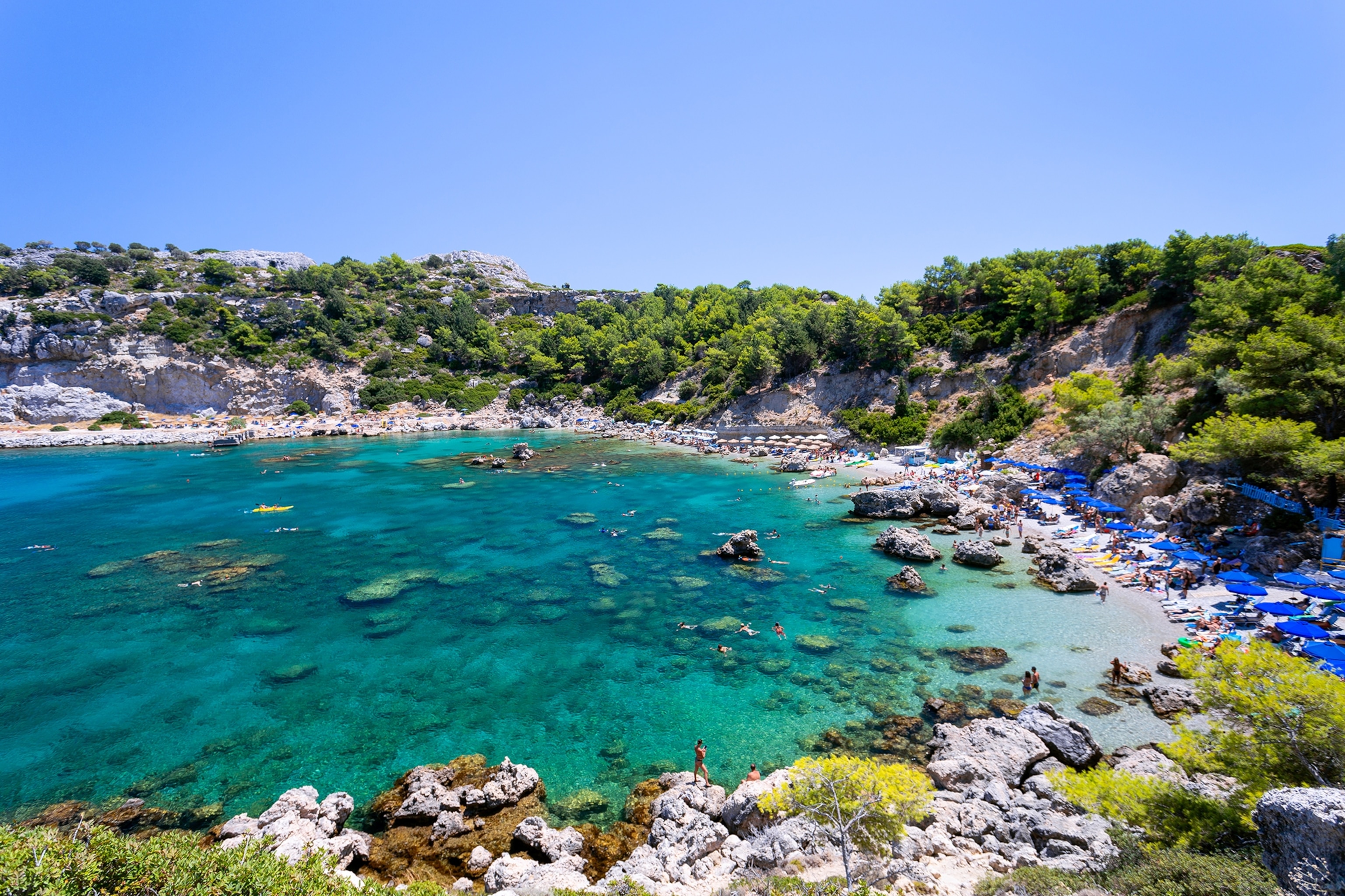 A top tow of a costal hilly terrain in Rhodes, Greece, with trees lining the hills