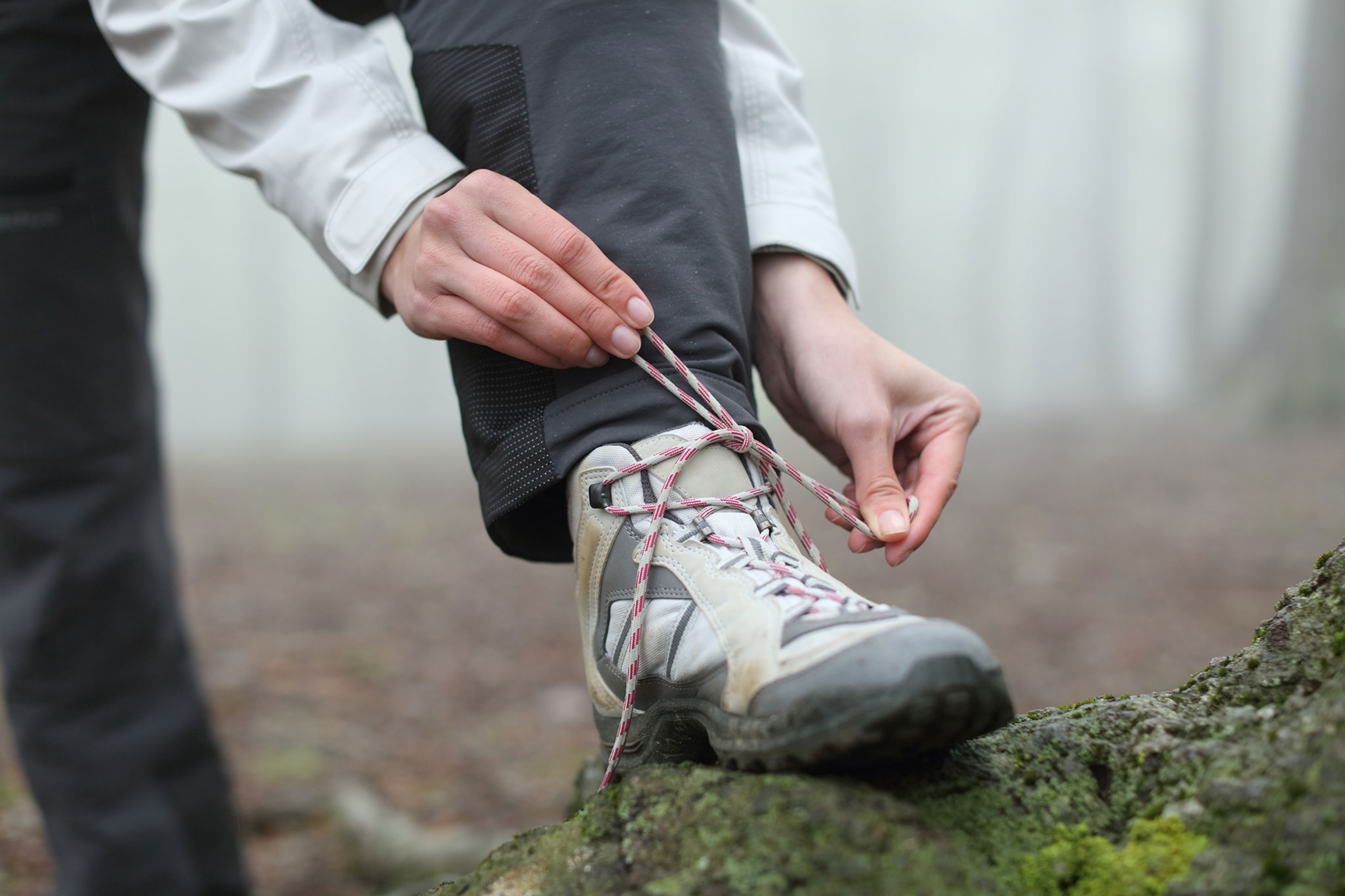 Person tying laces of hiking boots.