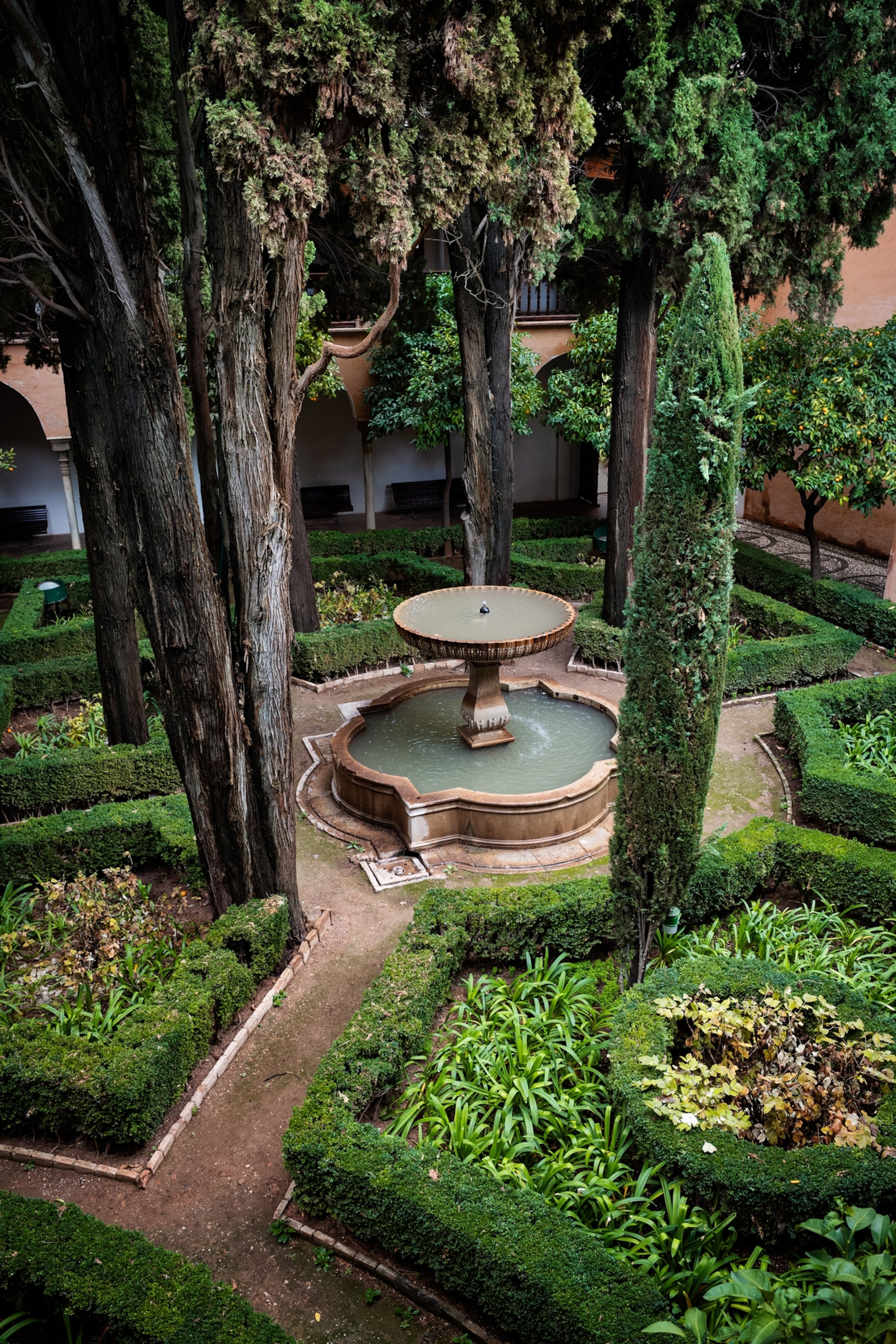 Look from above at the corner of a garden with the phountain in the middle.