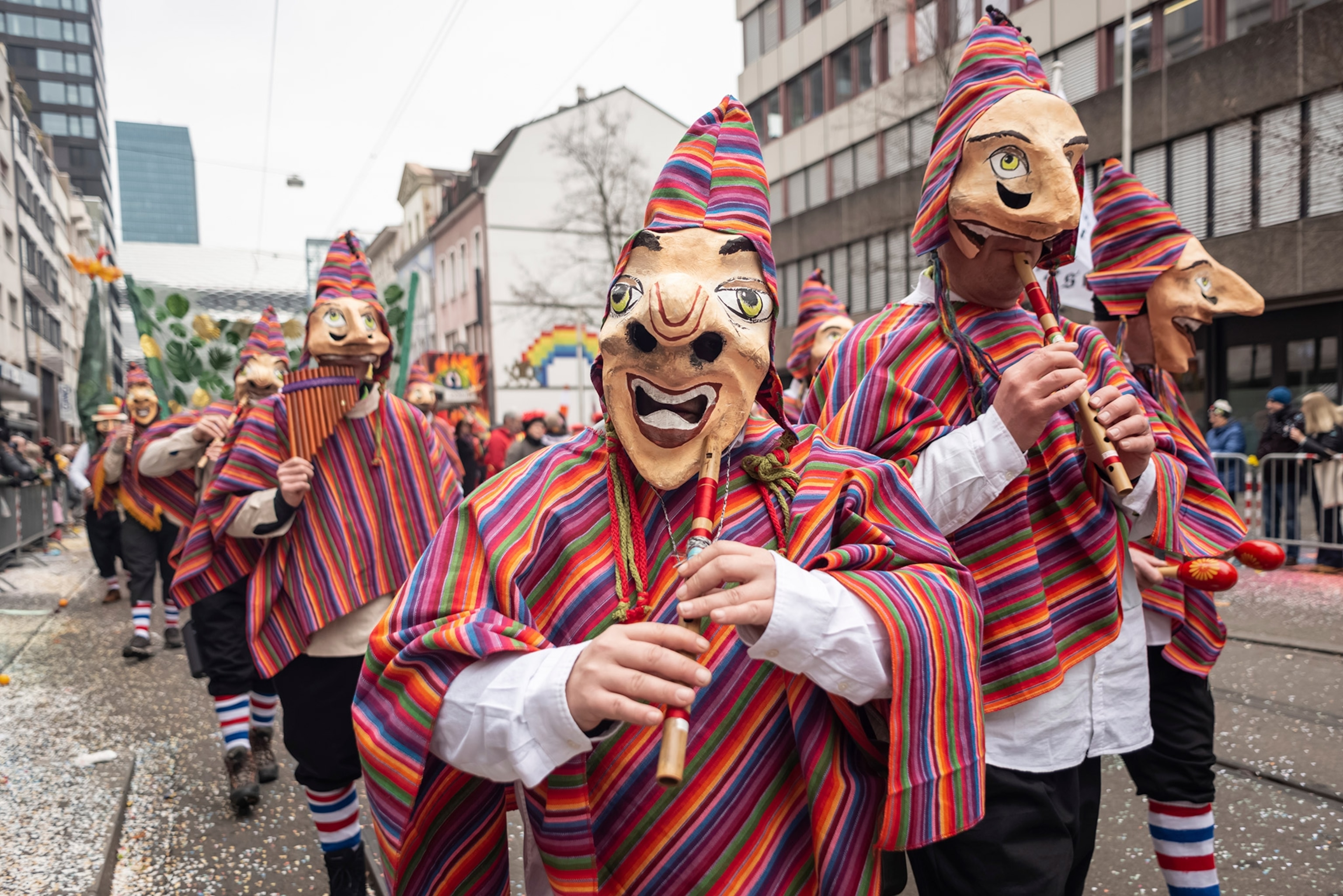 People wear masks and play wind instruments.