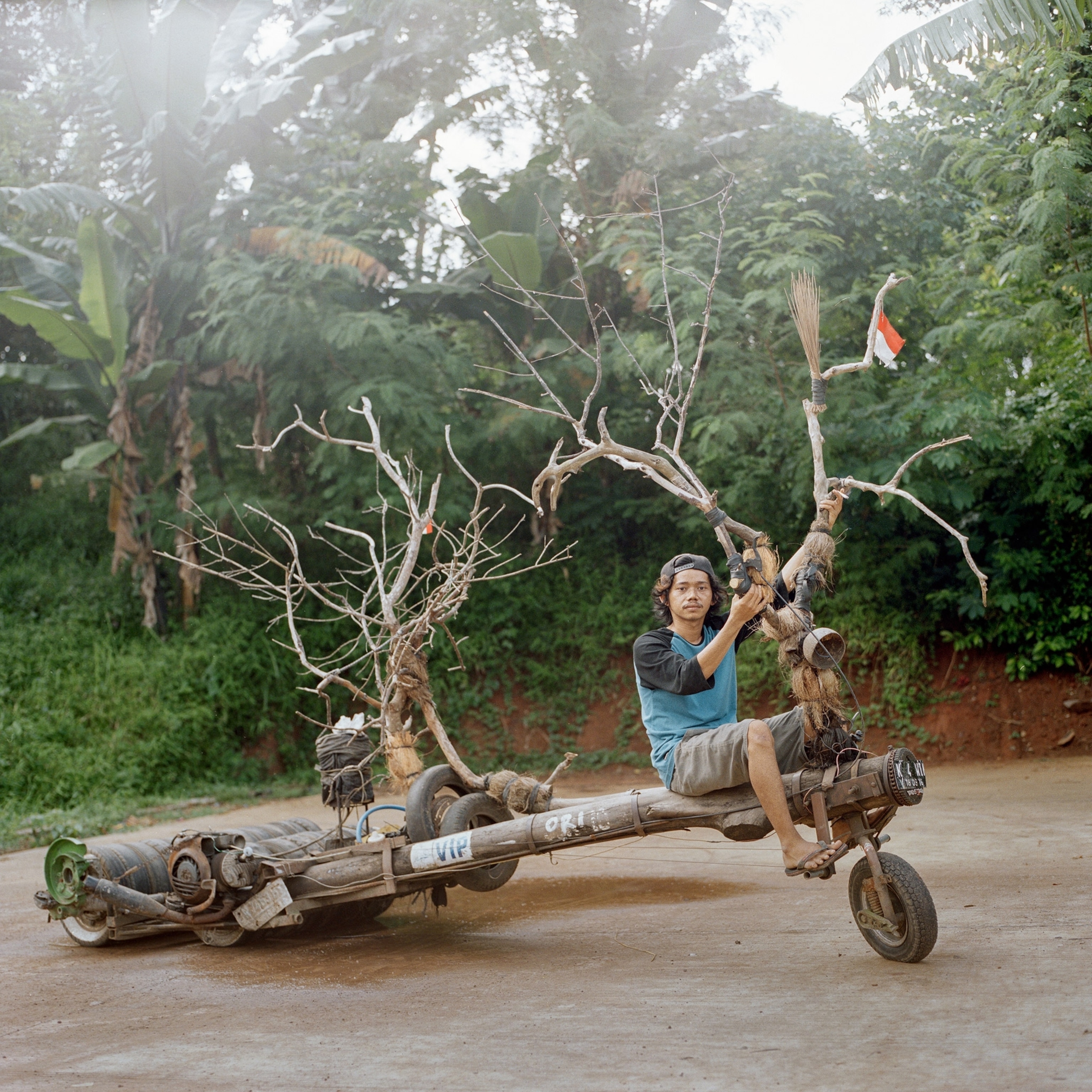 person on a scooter fashioned out of a tree in Indonesia