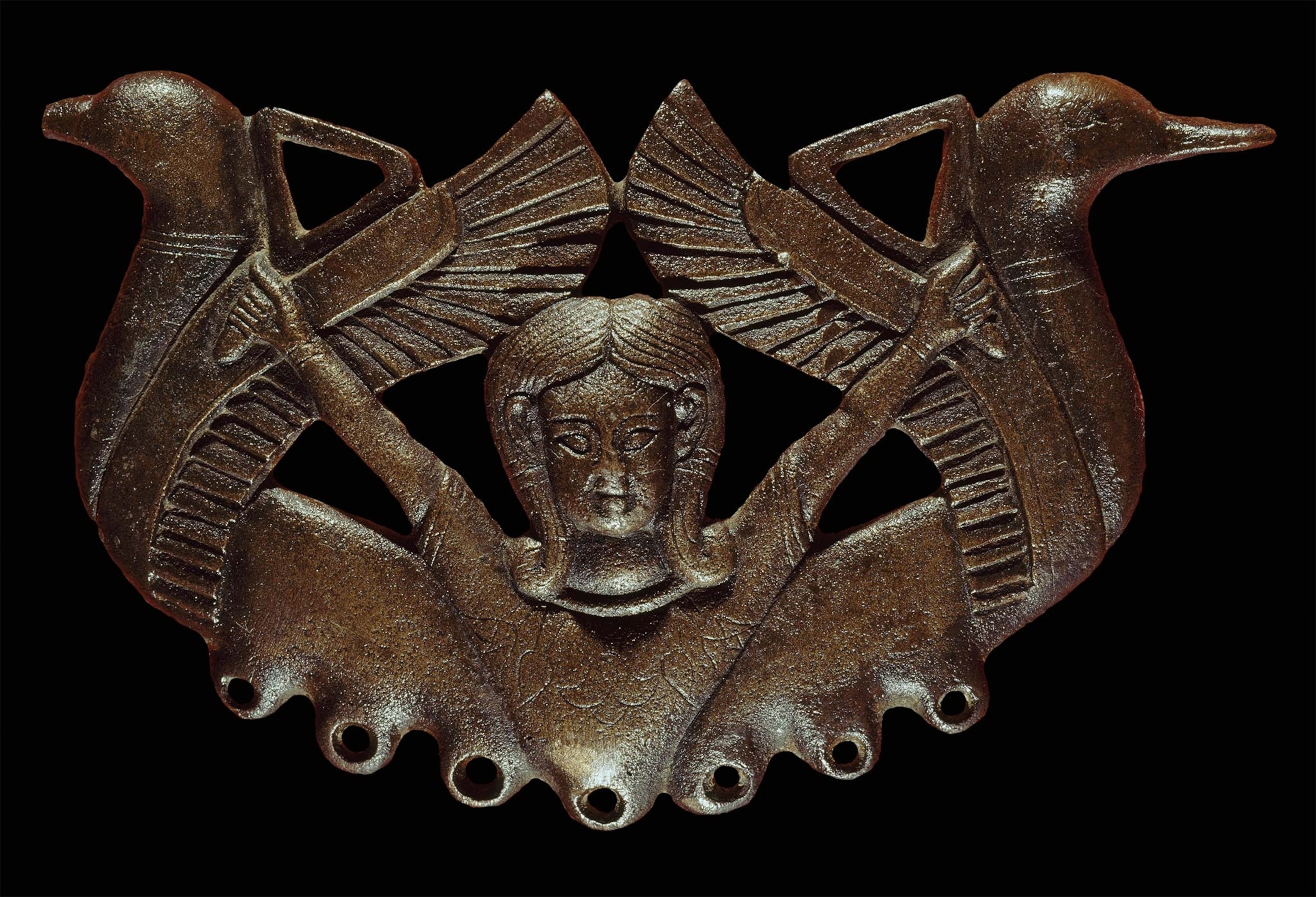 The goddess Astarte sits in the middle of a seventh-century B.C. bronze horse bit.