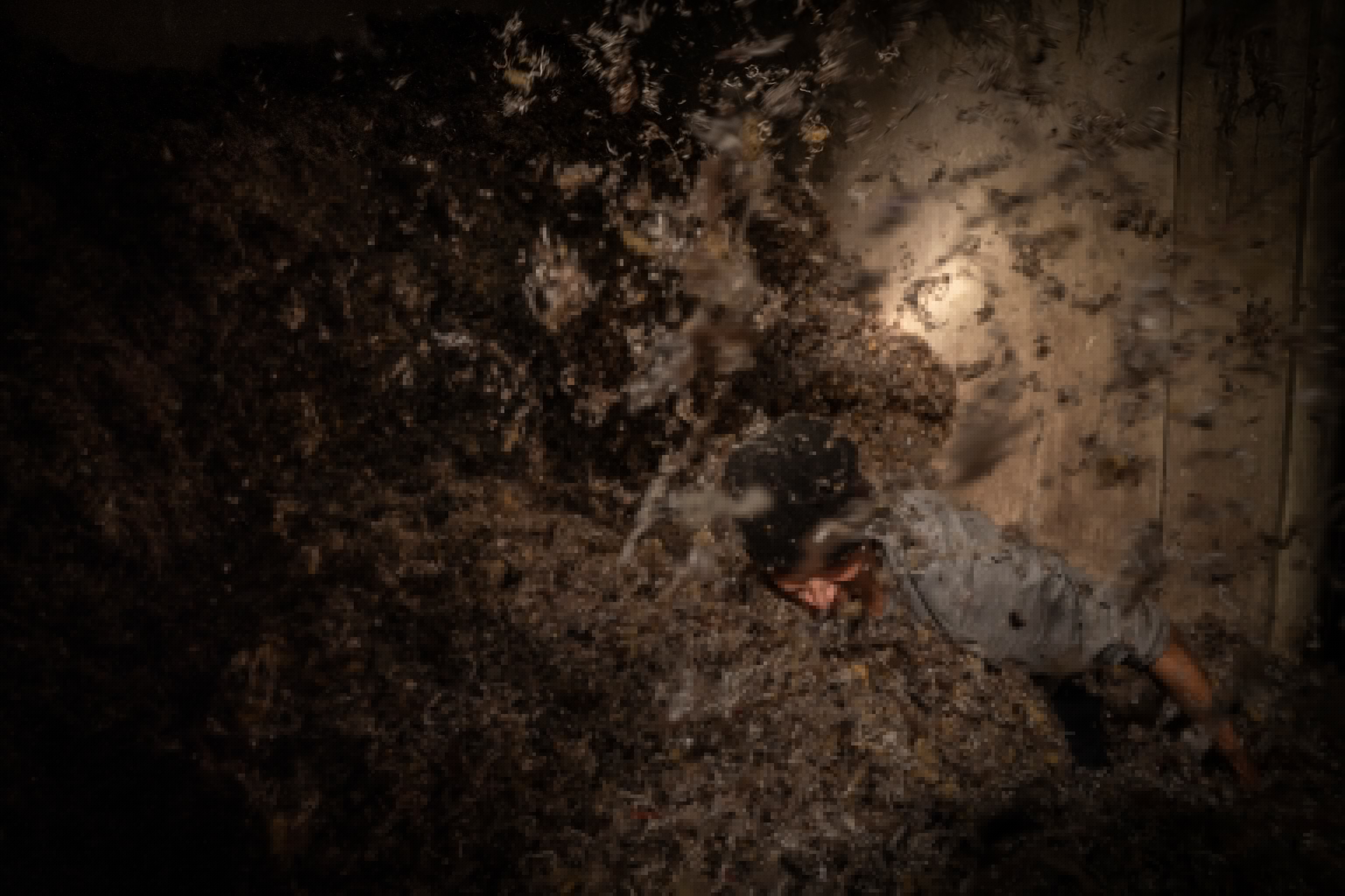 Shot was taken above a person standing with a pile of clothing scraps