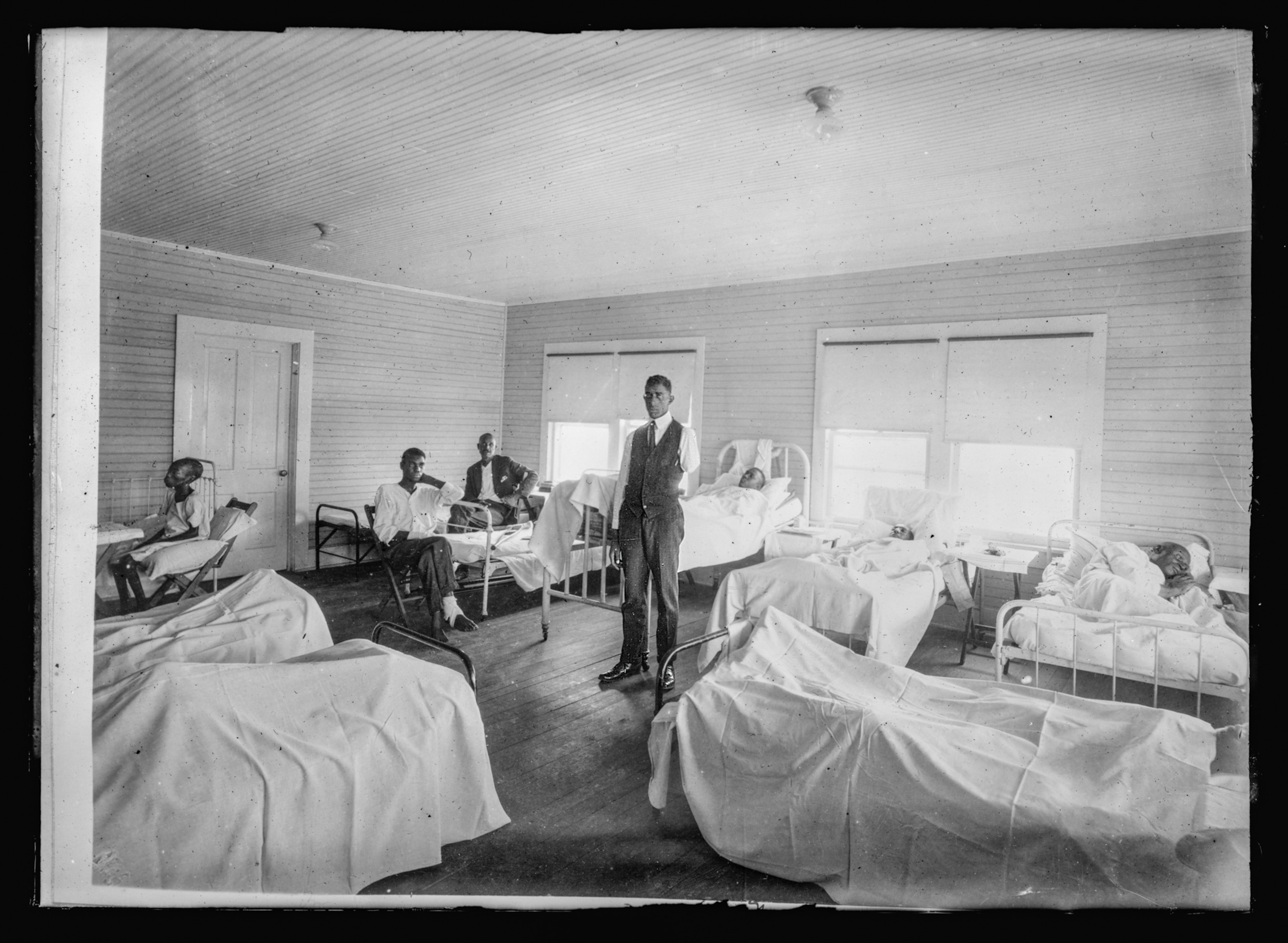 A group of people some injured with white sheet s covering their bodies.