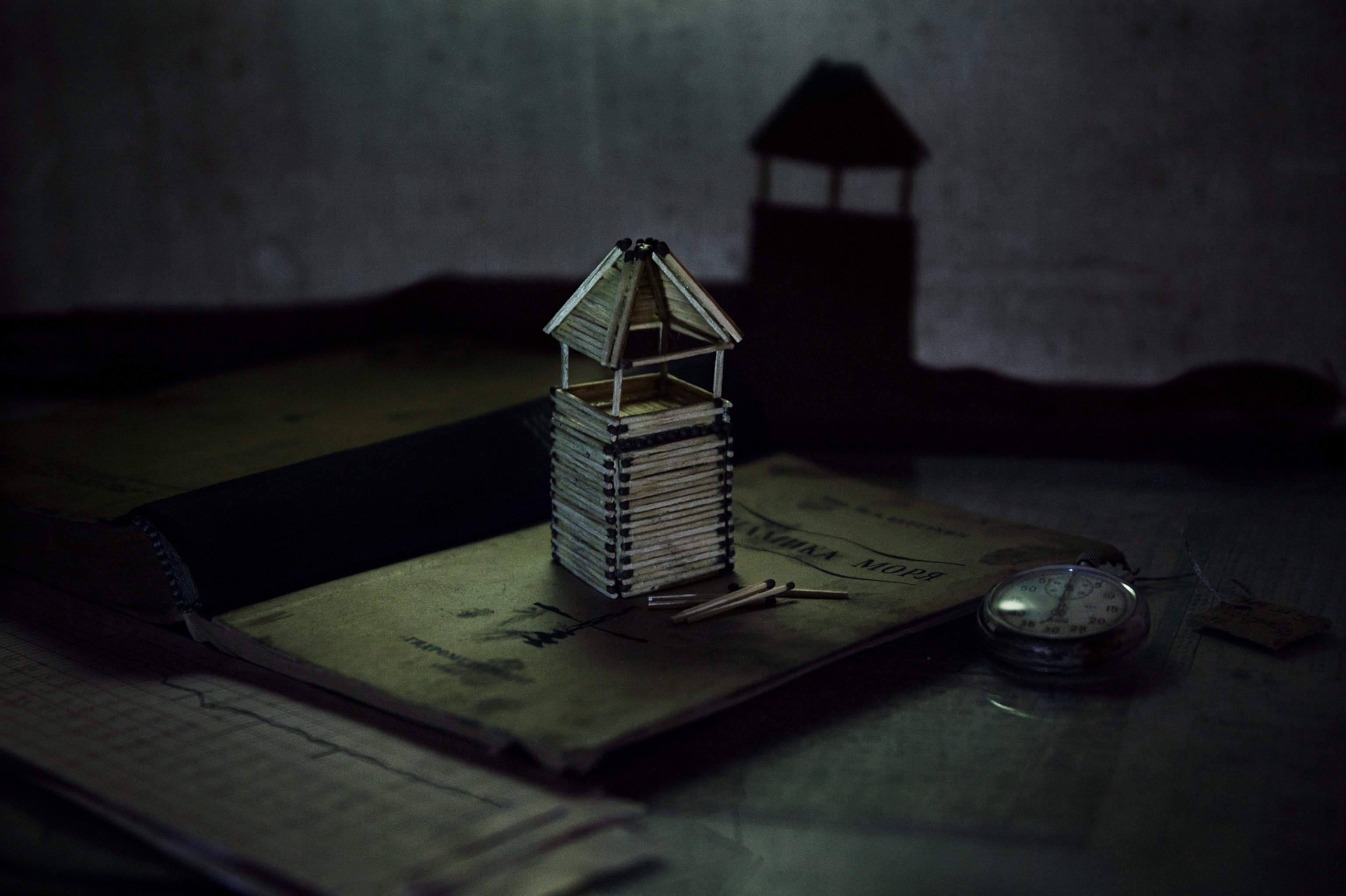 small lighthouse model on top of large book.