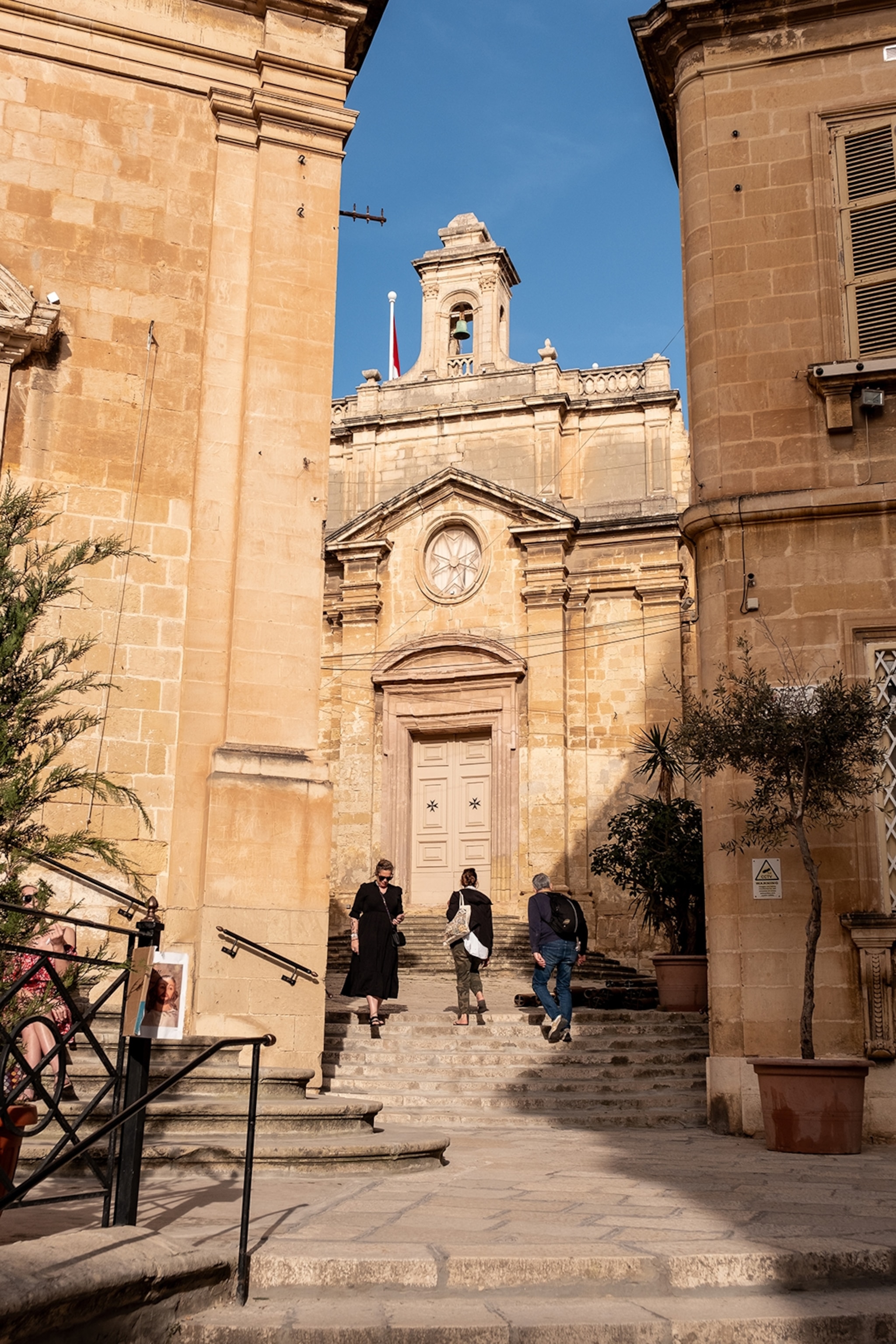 People walking up and down the steps of a historical building in Vittoriosa, Valletta.