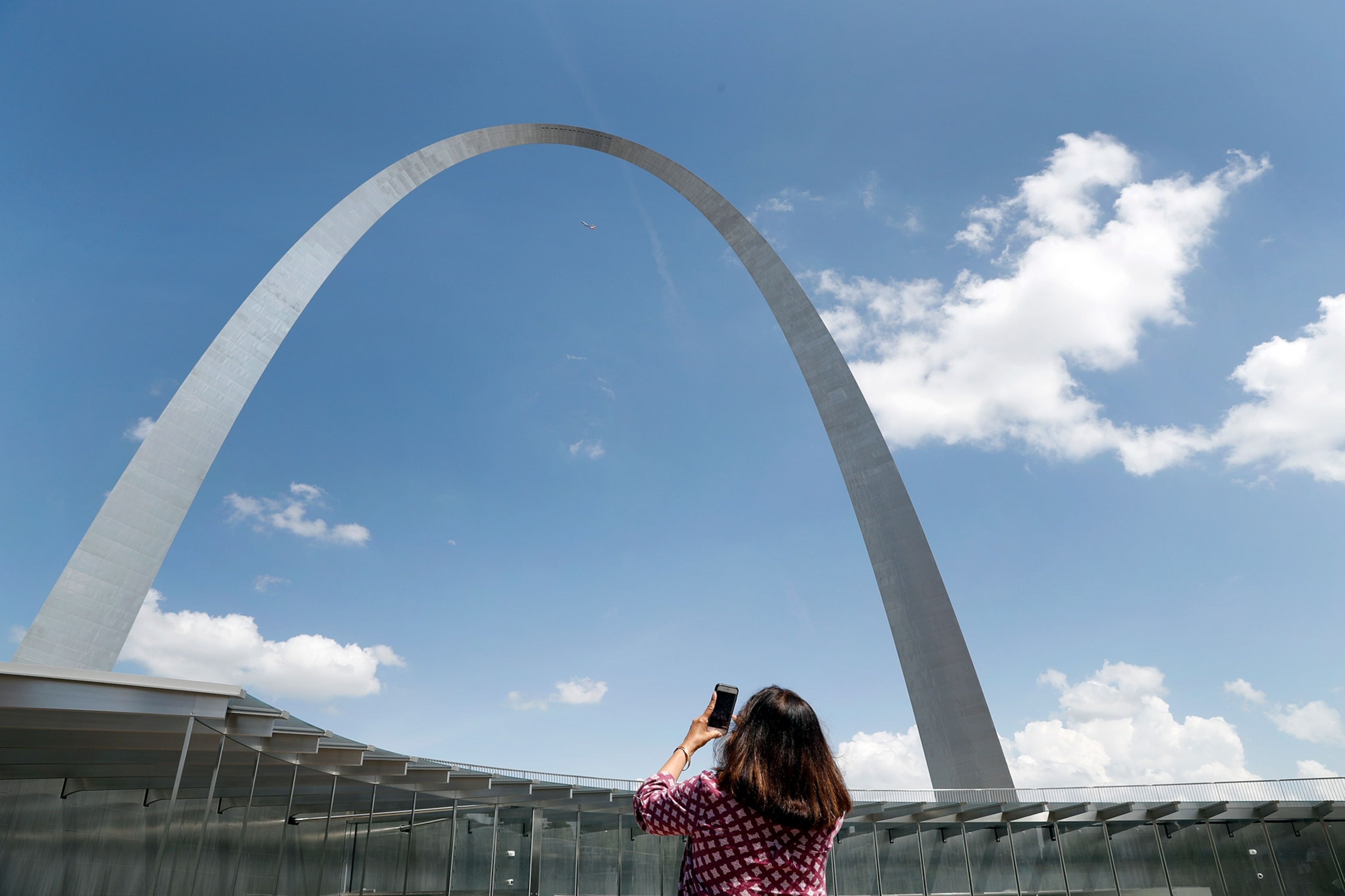 a person taking a cellphone photo of the Gateway Arch in St. Louis