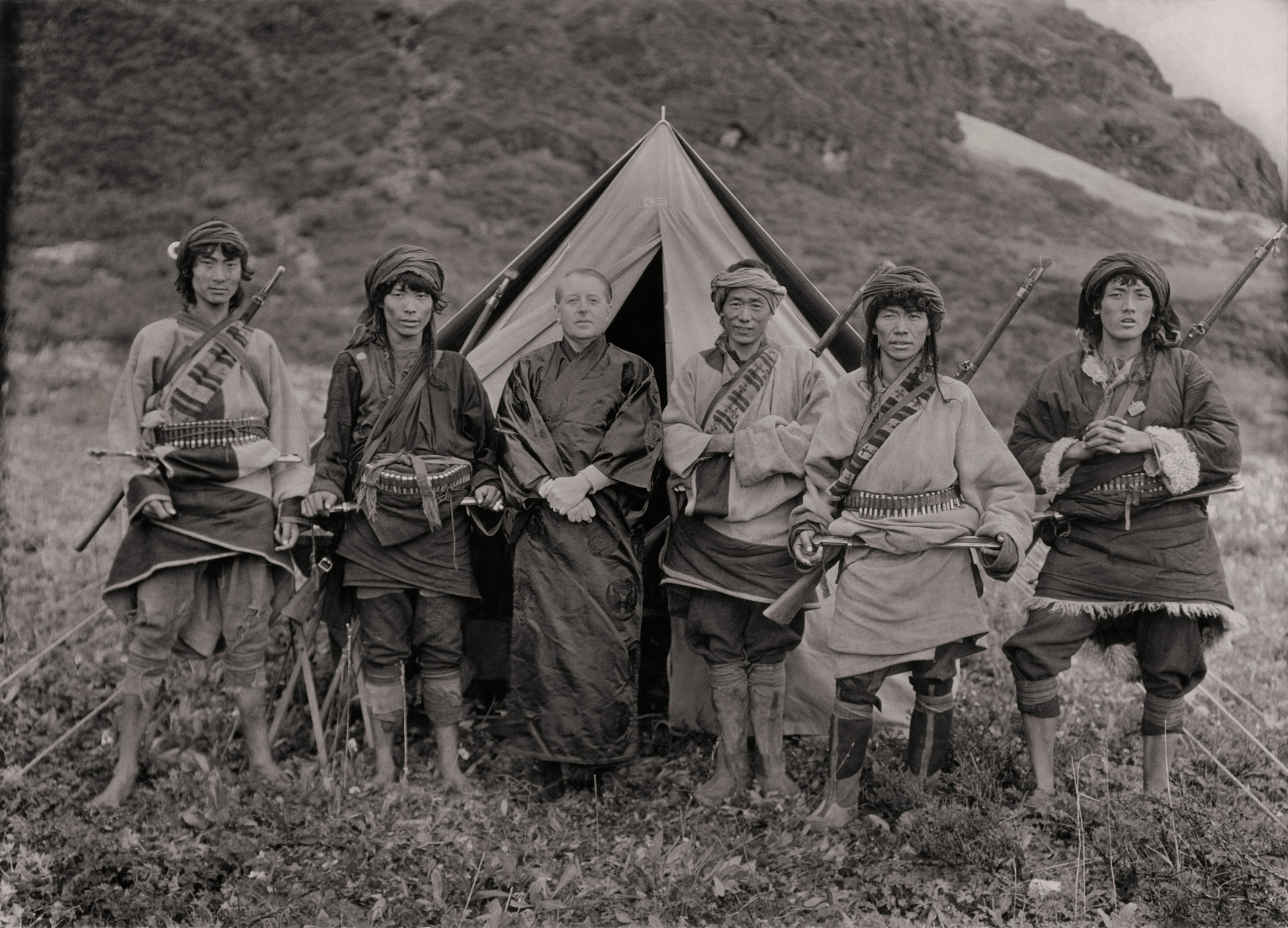 Black and white photo of Joseph Rock surrounded by Chinese men