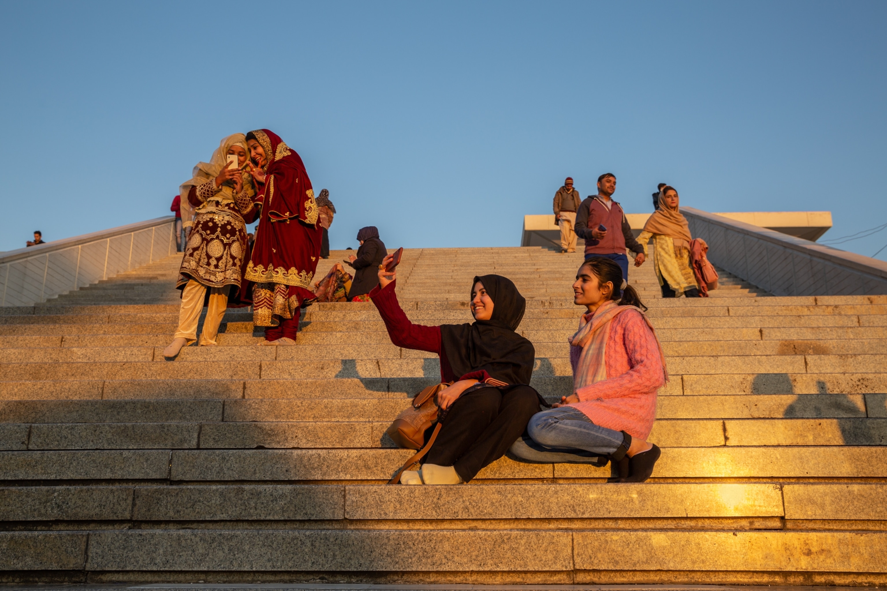 two young women take a selfie as the sun sets