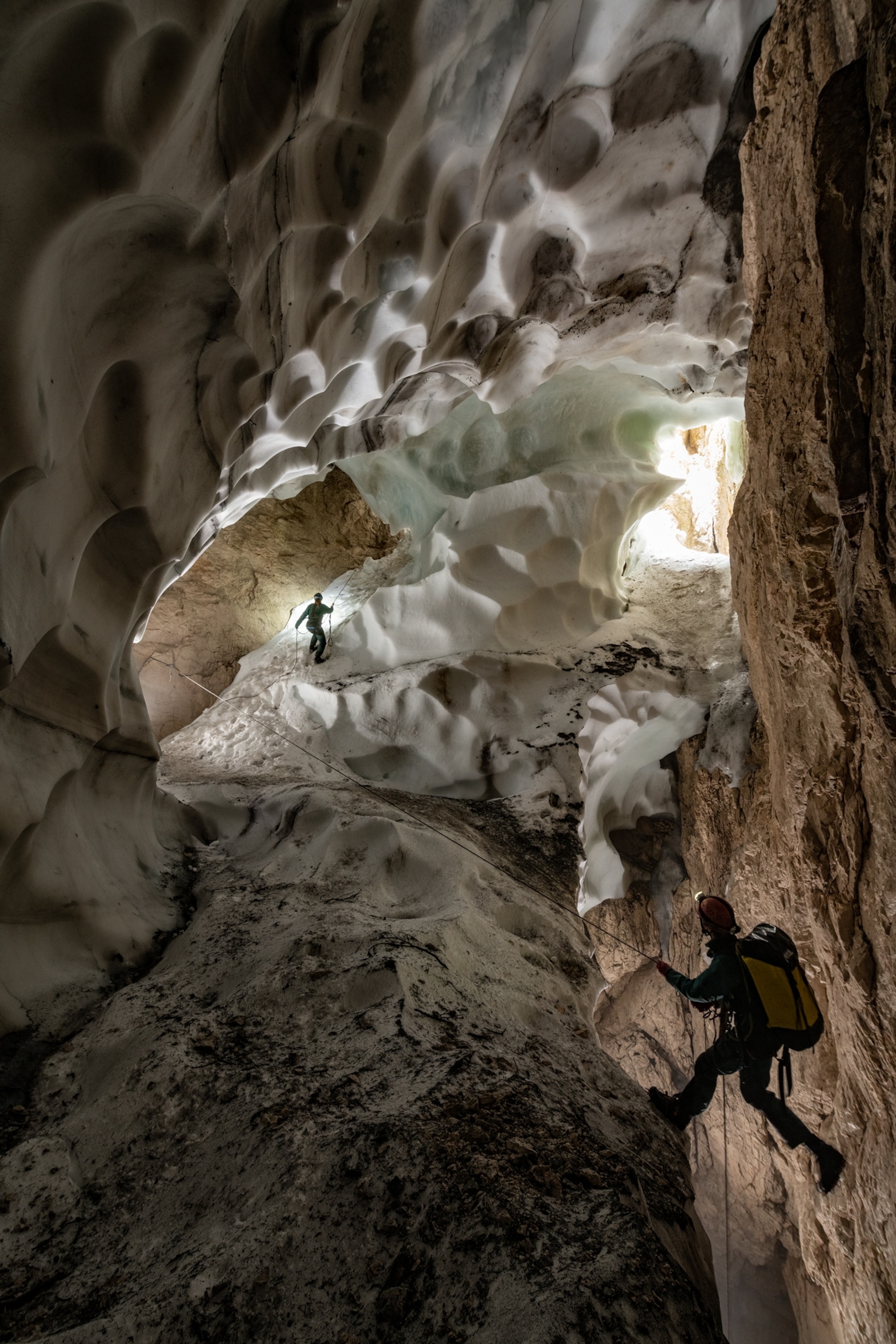 Picture of two people in cave with scalloped snow walls.