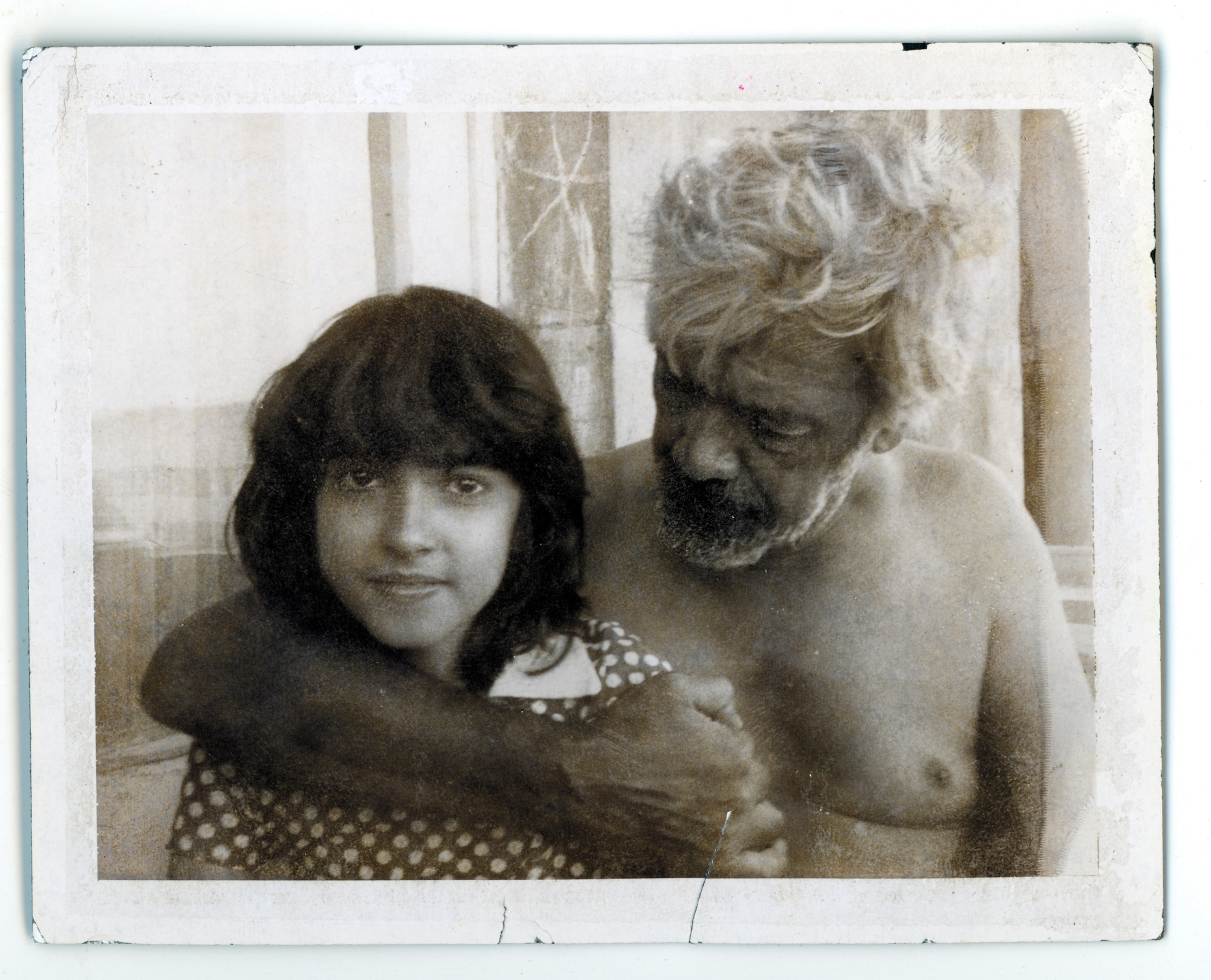 A father stands with his arm wrapped around his daughter's shoulder for a portrait.