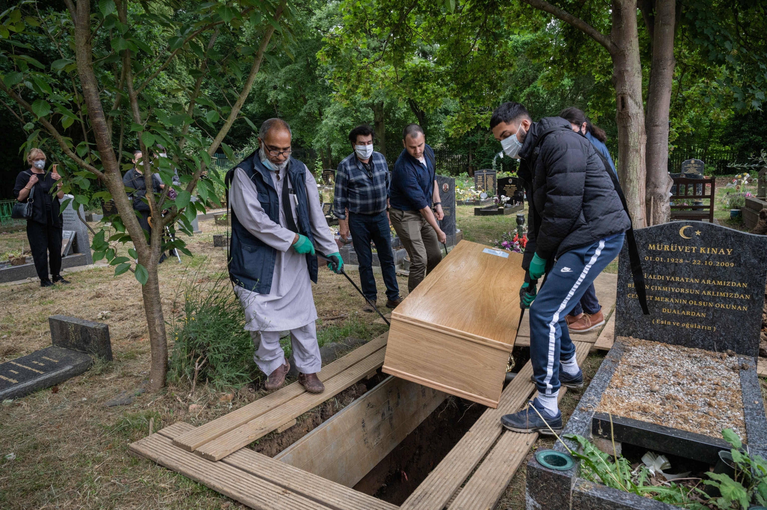 men lowering a casket into a gravesite