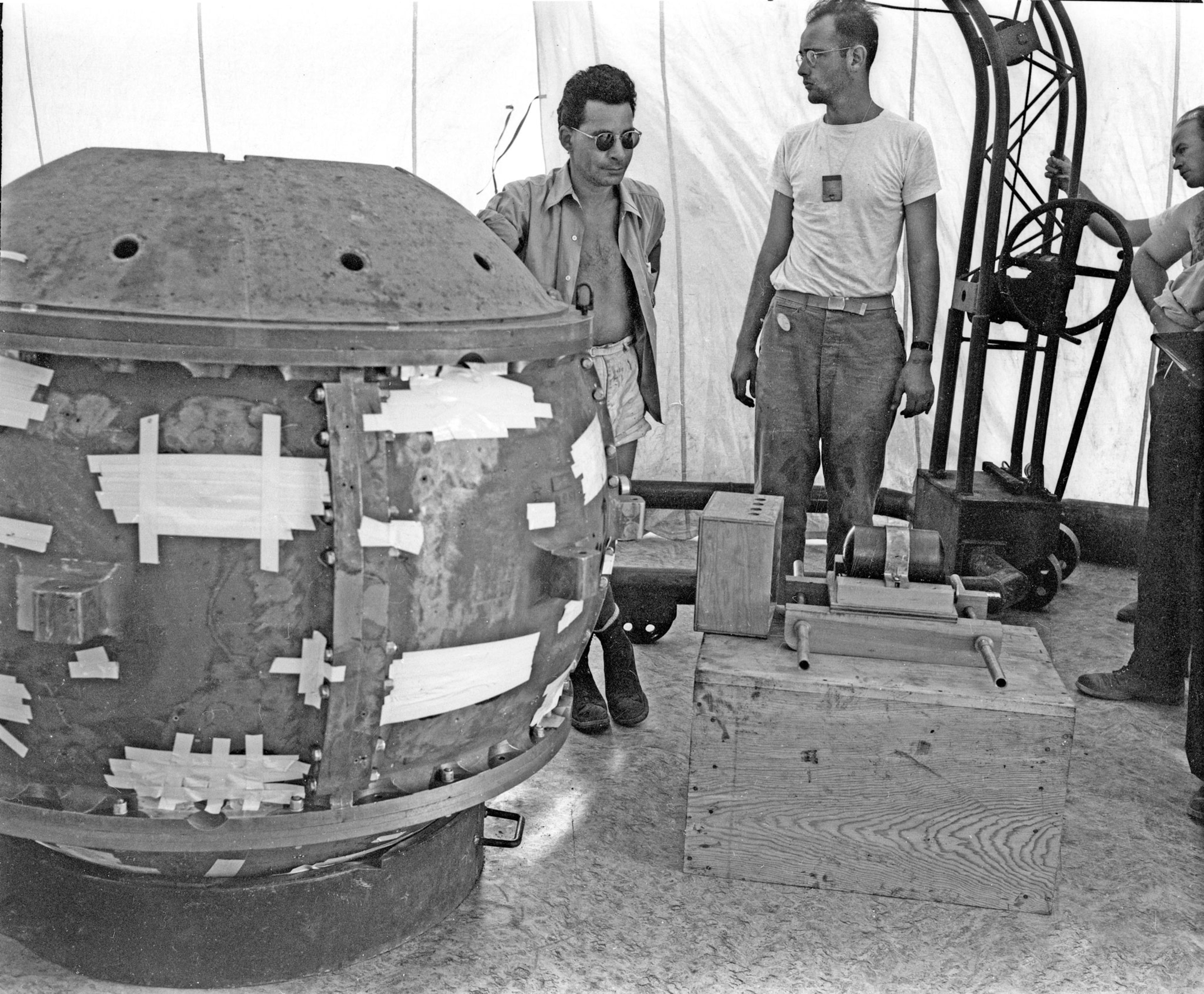 two men standing beside a large metal sphere