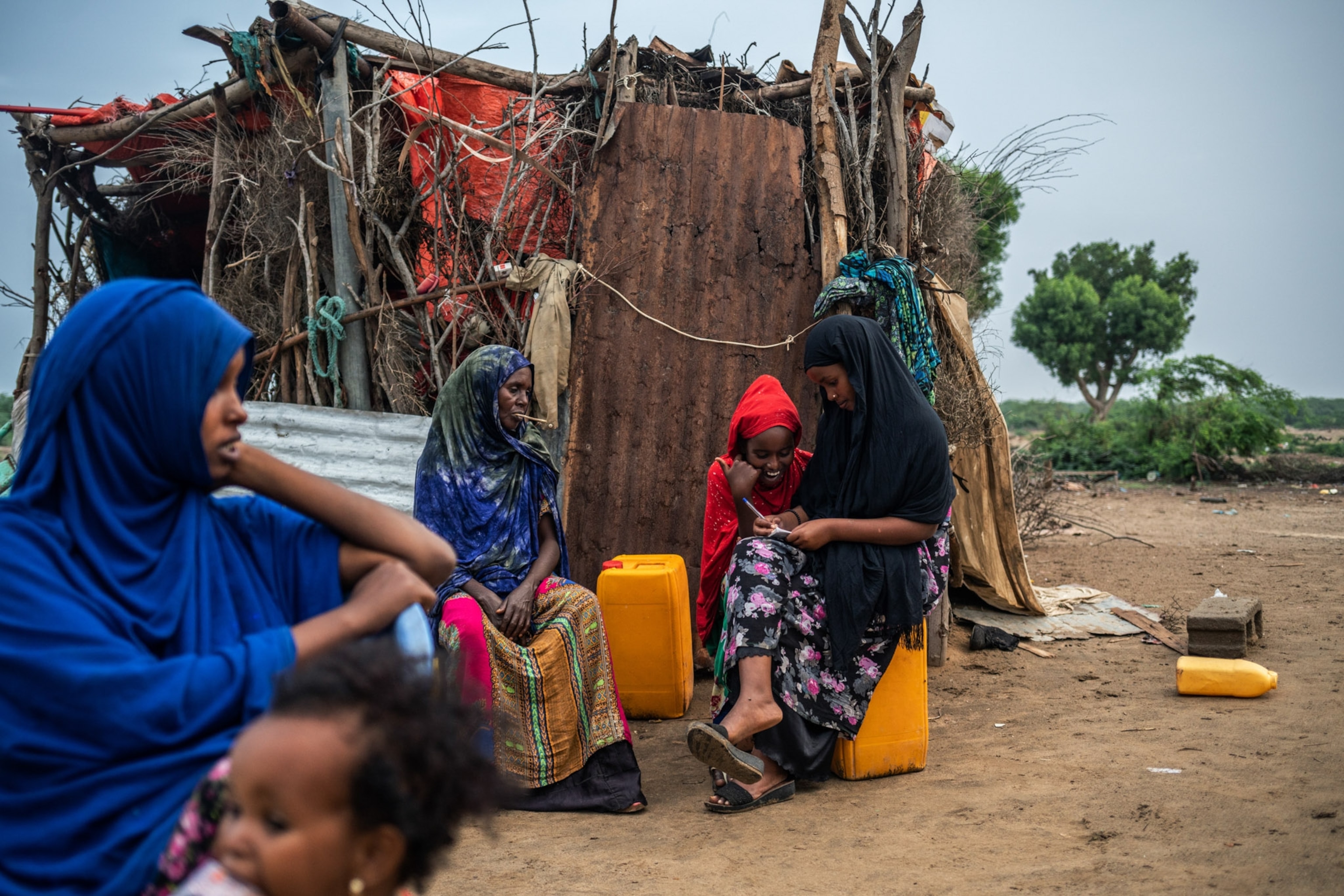 a group of women of all ages sitting outside of a home