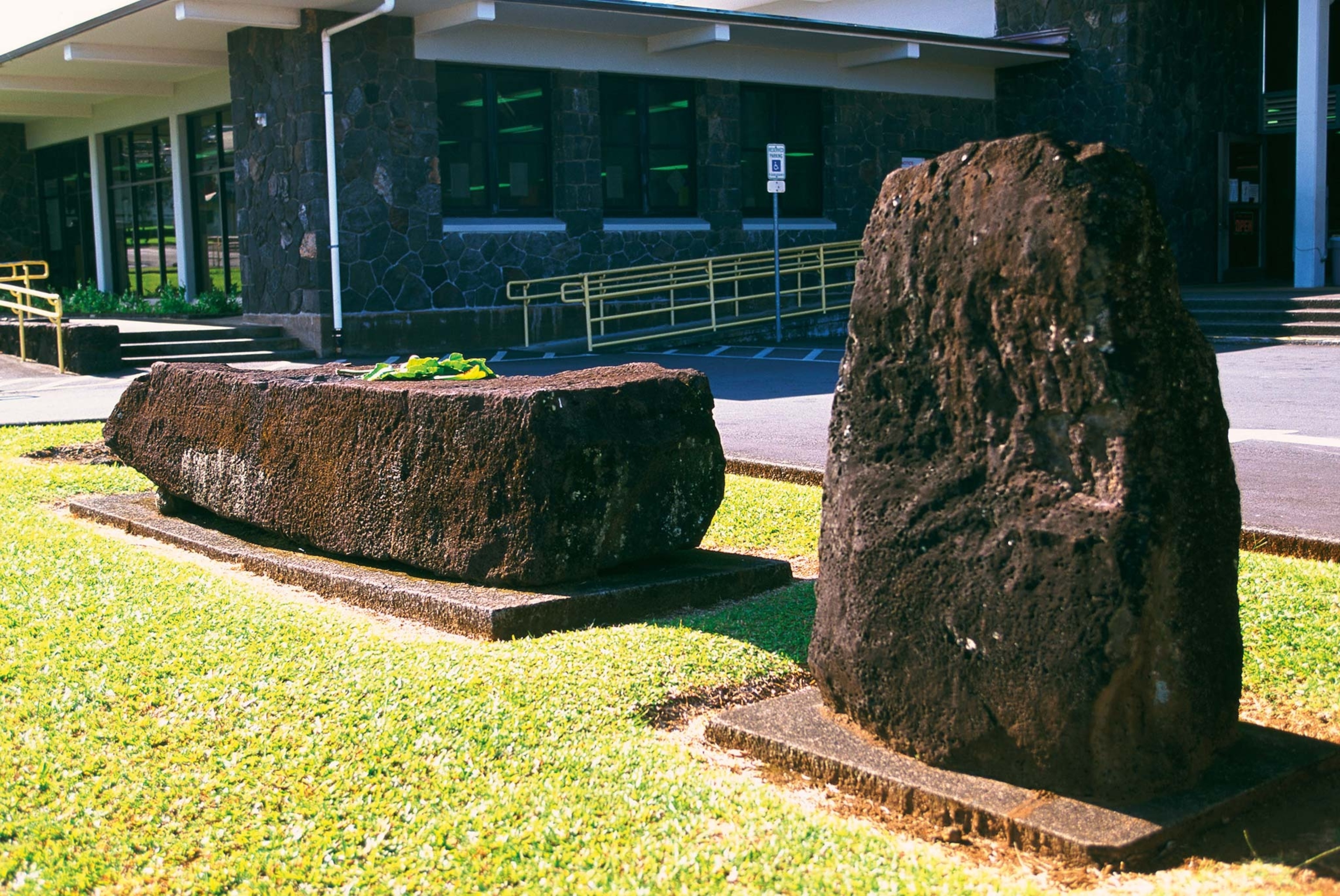The Naha Stone on the left sits before the Hilo Public Library on the Big Island of Hawai‘i.
