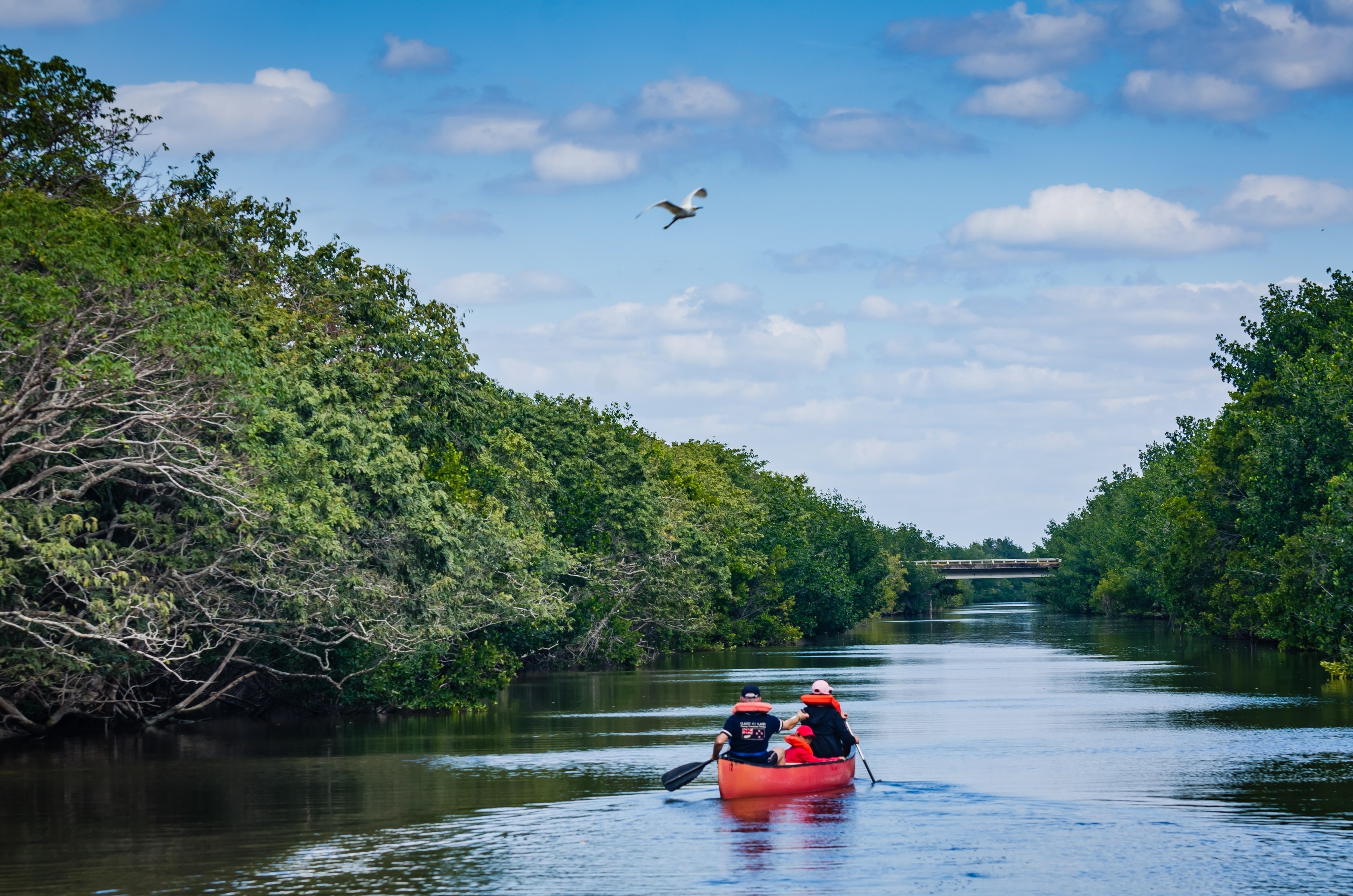 Family rows a red canoe on Biscayne Bay Lagoon at Biscayne National Park in Florida