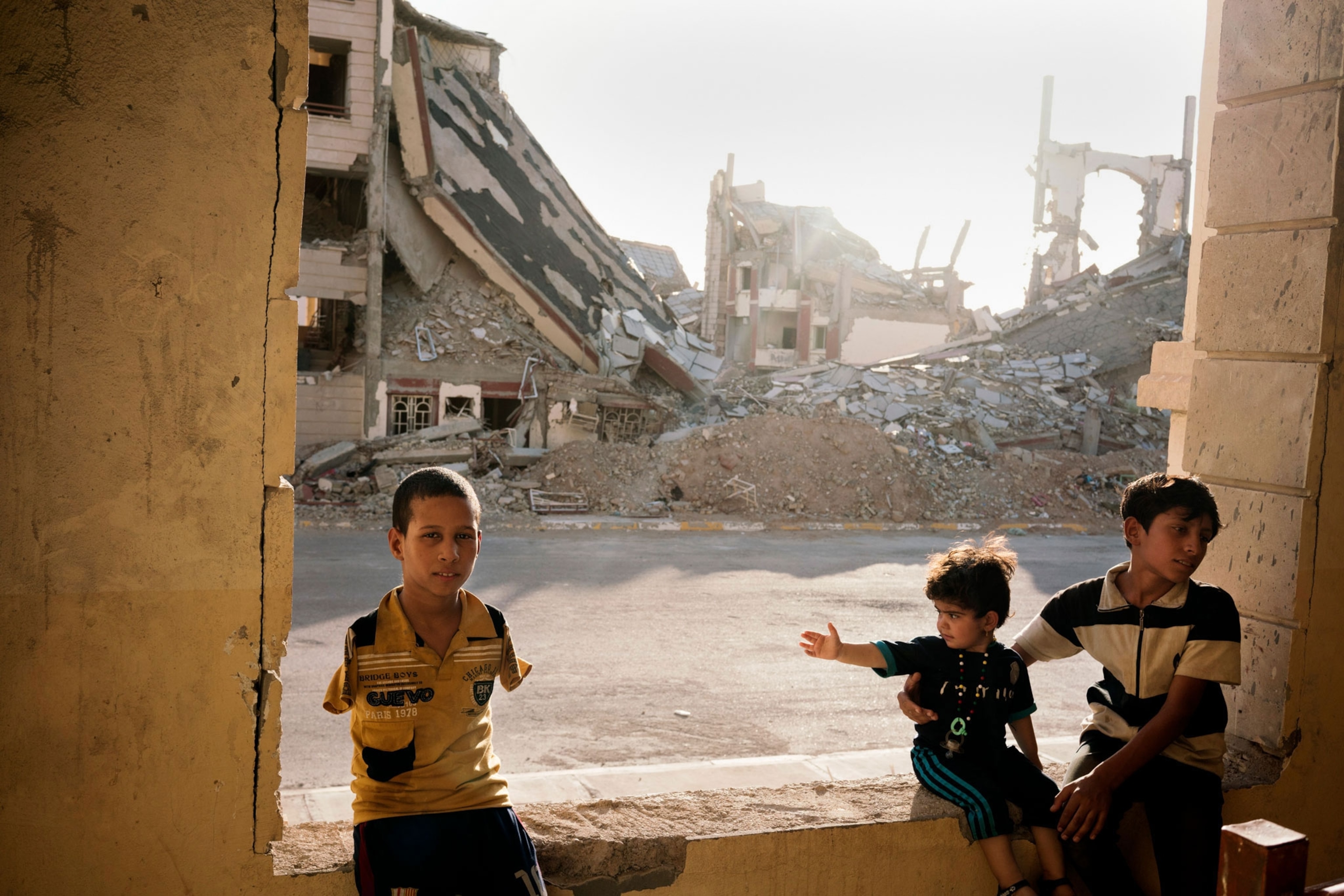 displaced children in the rubble of an apartment complex