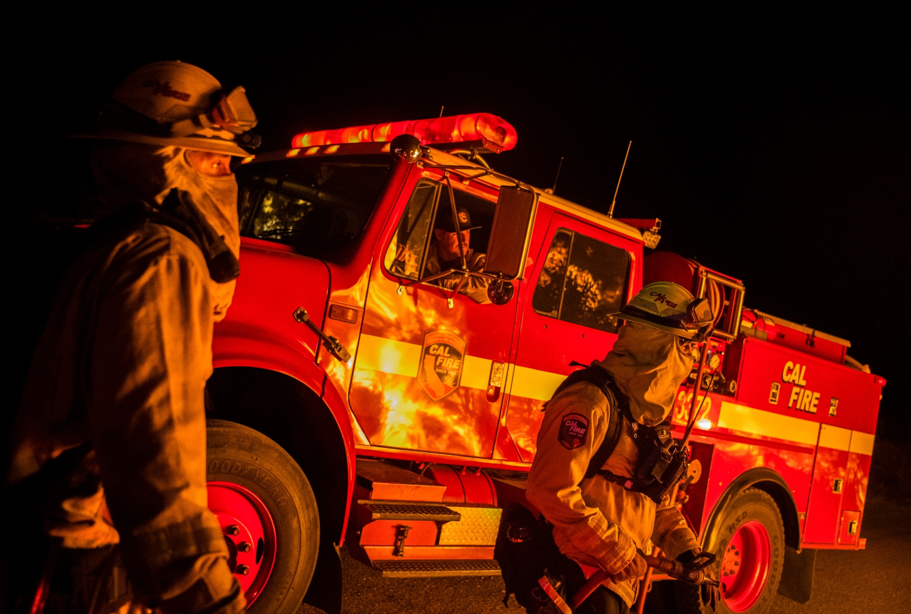 firefighters viewing the flames from their engine