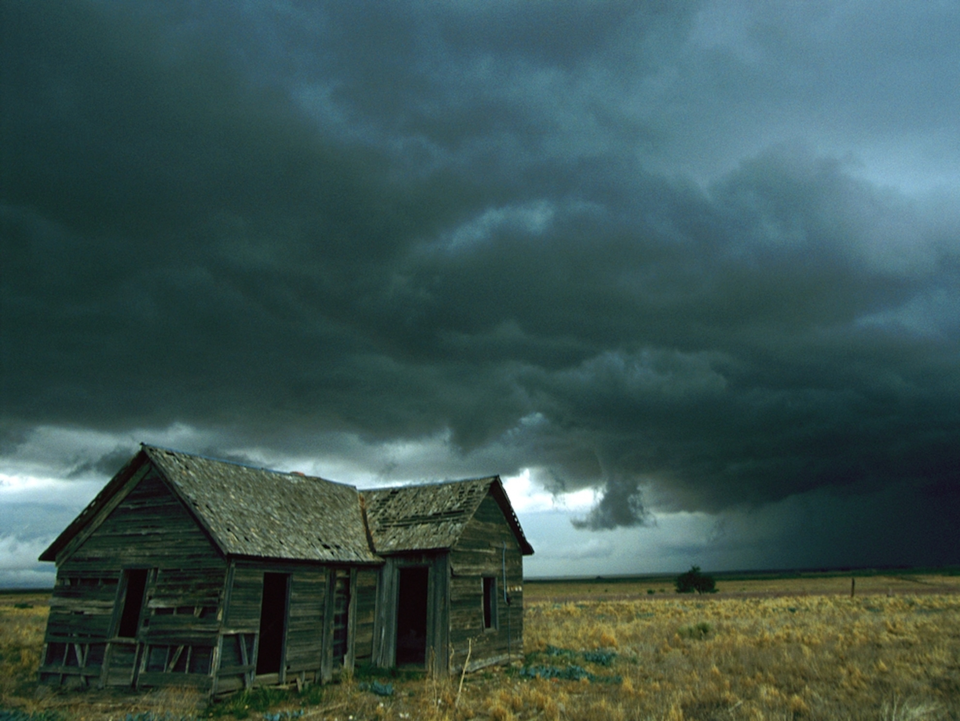 Stormy skies behind a dilapidated wooden house