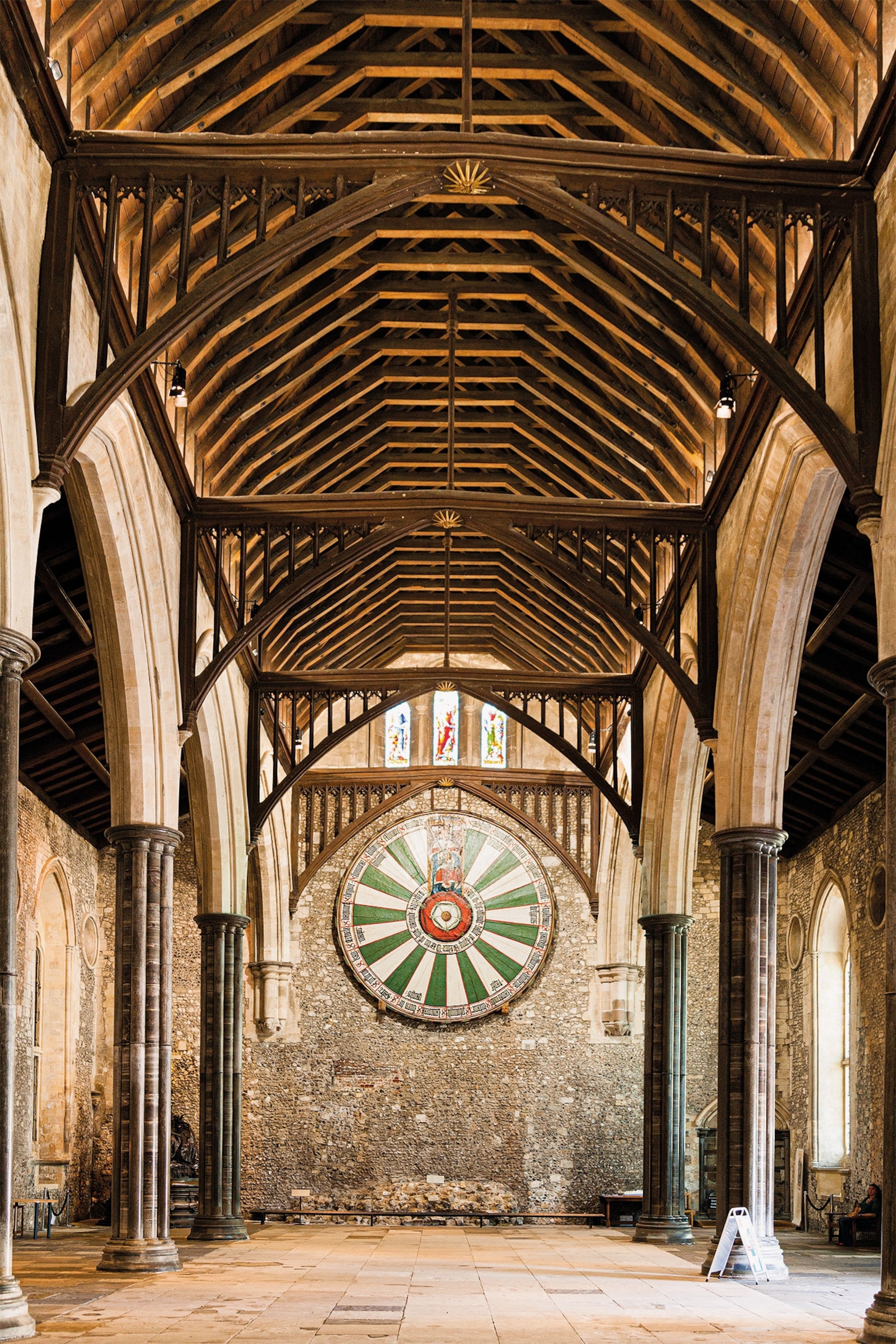 A view of a reconstruction of King Arthur's round table hanging on the wall inside a castle's hall