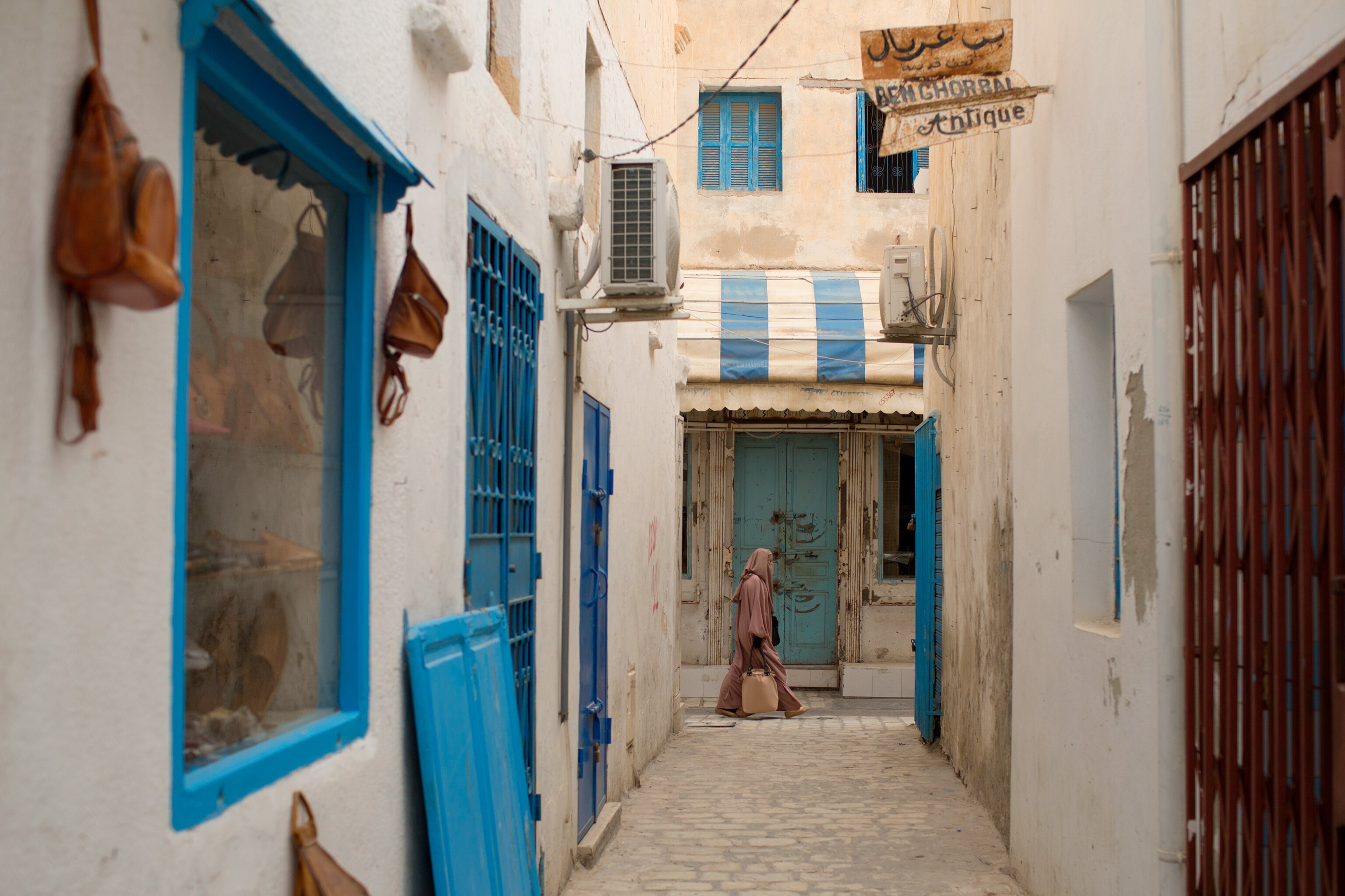 a person walking along a street in Houmt Souk, a city in Djerba, Tunisia