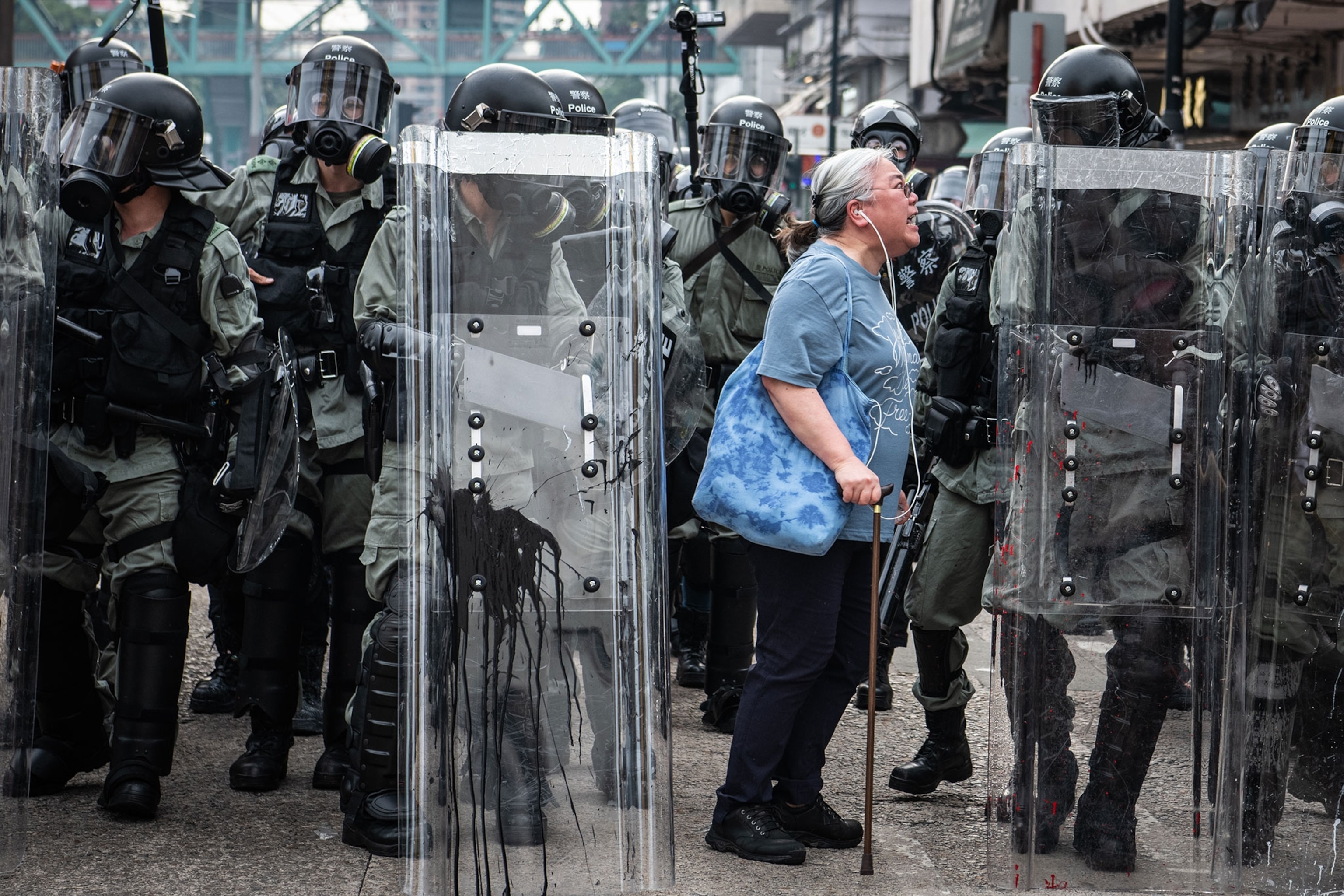 an elderly woman shouting at the police at a protest in Hong Kong