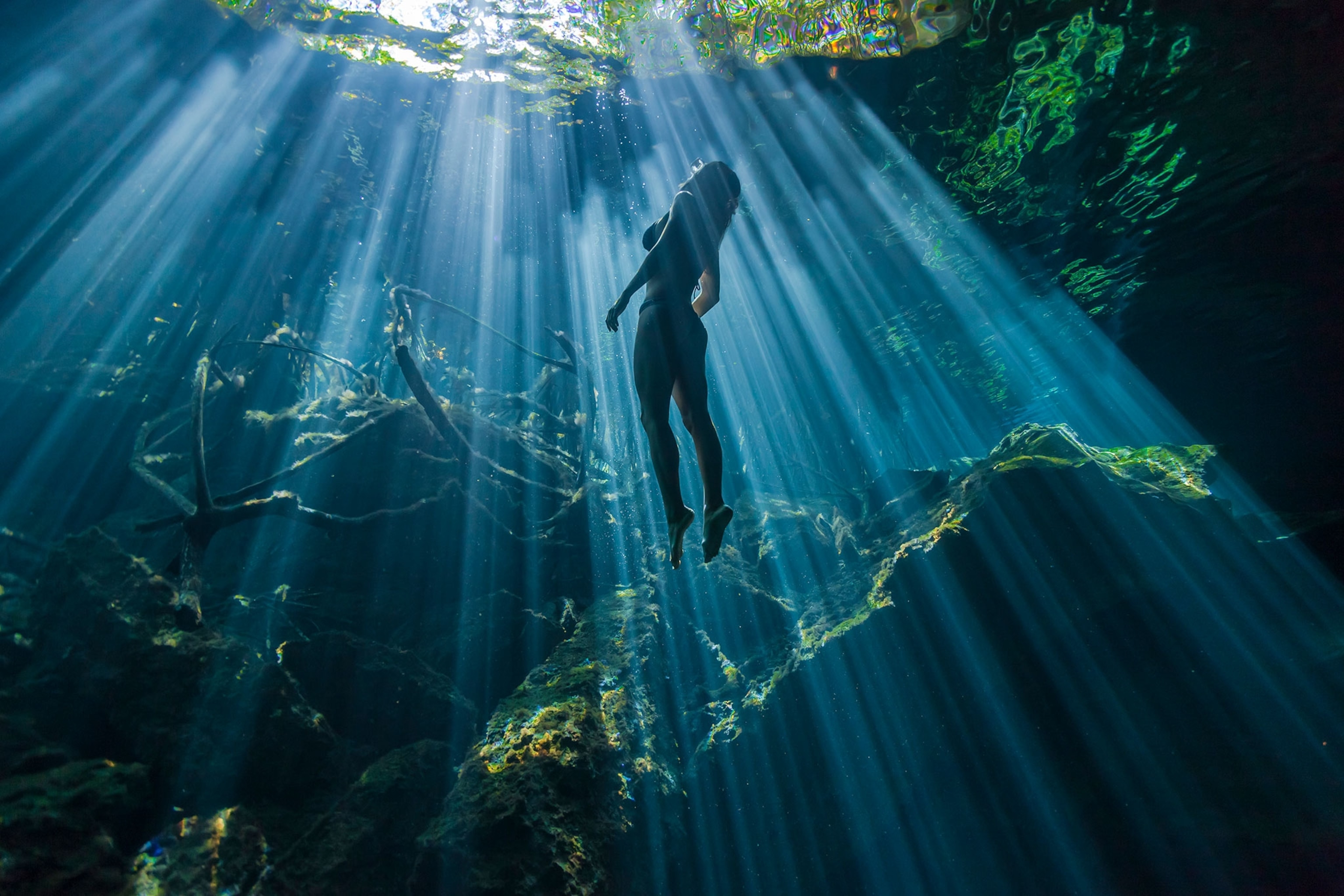 a woman swimming in Cristalino Cenote in Mexico