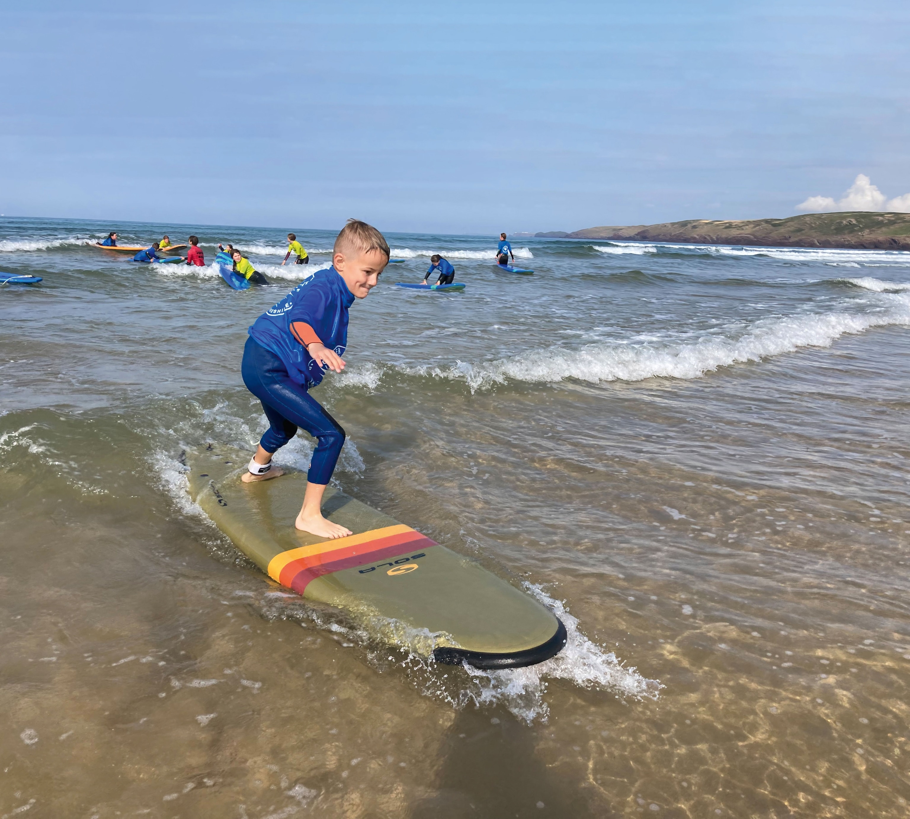child surfing small wave near shore