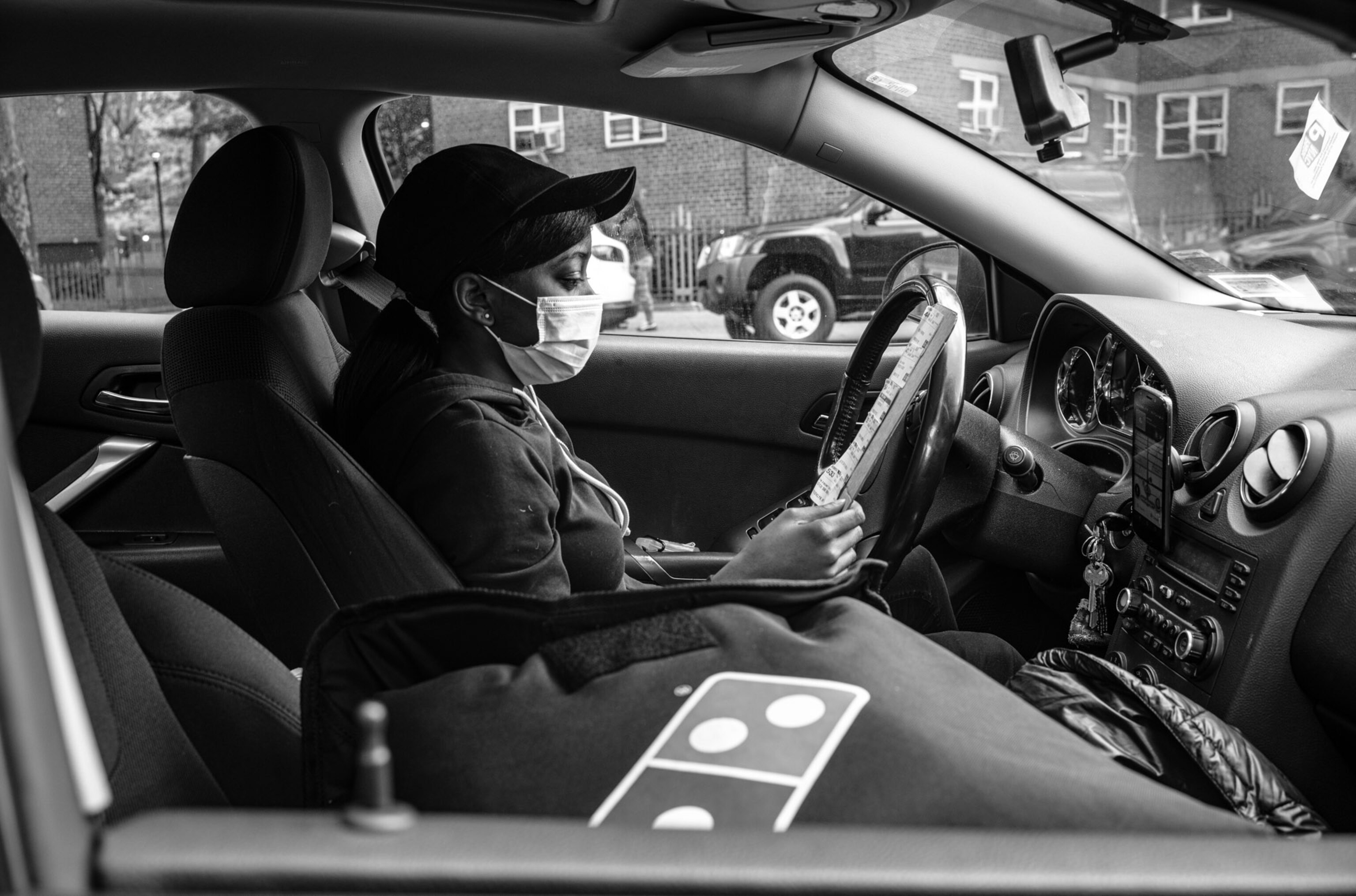 a person in a drivers seat looking at their clipboard