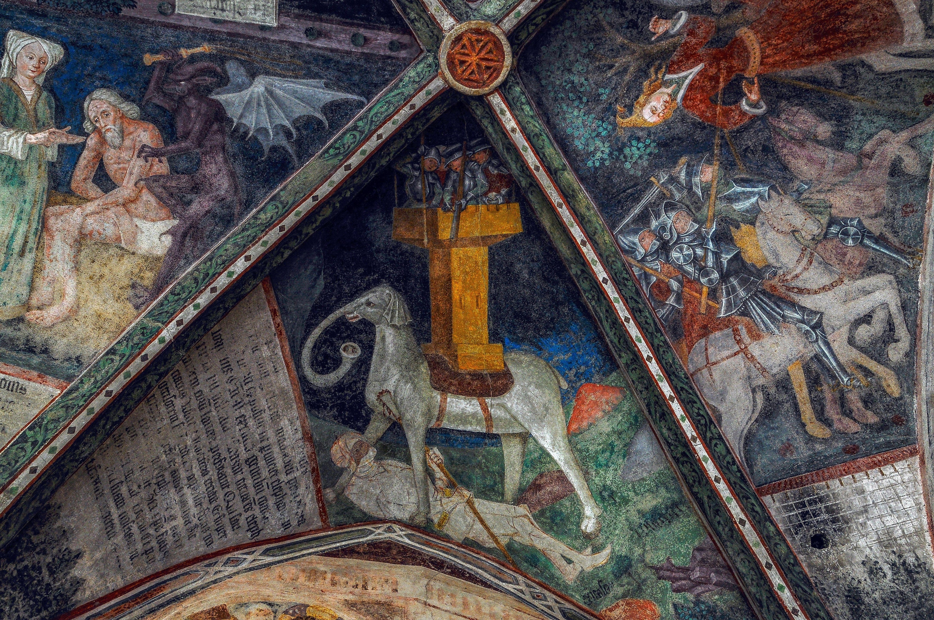 An upward view of an elephant that resembles a horse trampling a man.