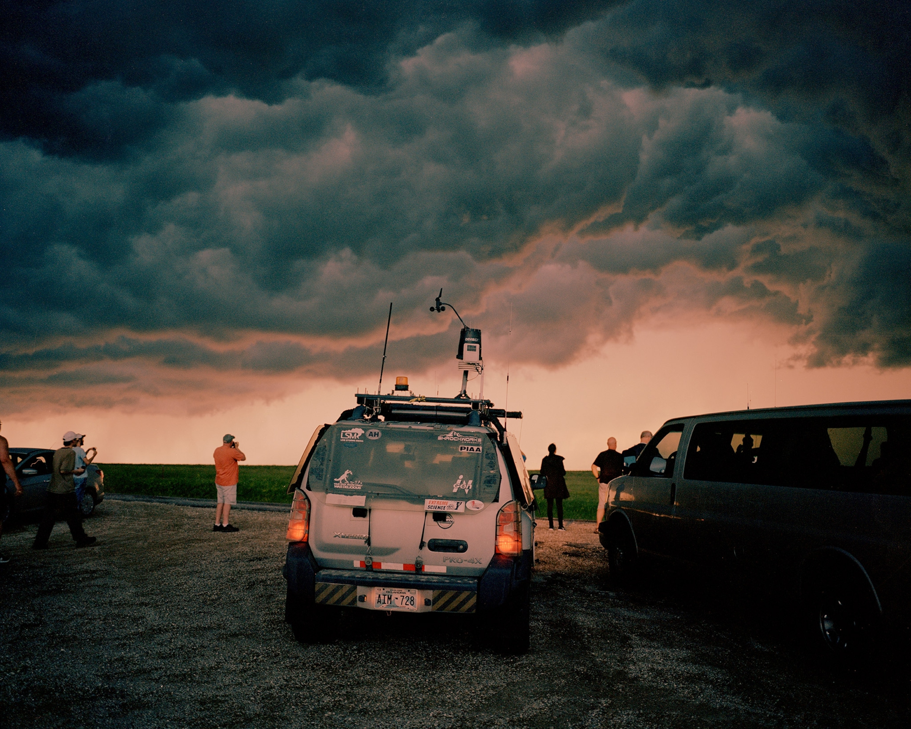 a tornado chasing vehicle parked in front of a shelf cloud in Kansas