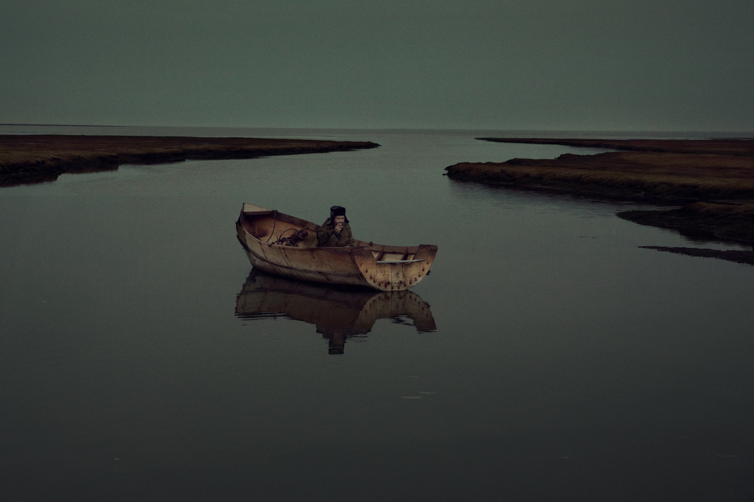 man on a boat in the middle of a stream.