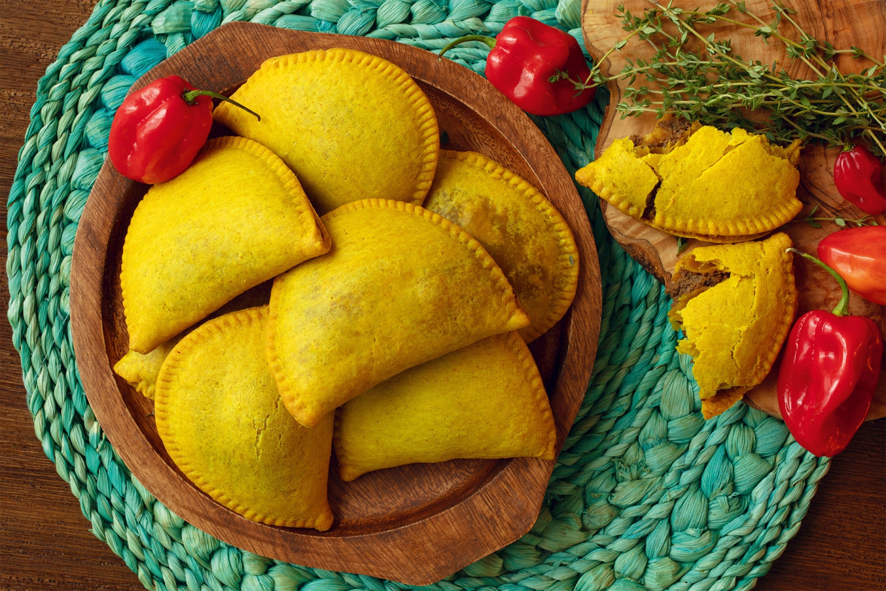 Overhead shot of Jamaican Beef Patties on ​a turquoise table mat.